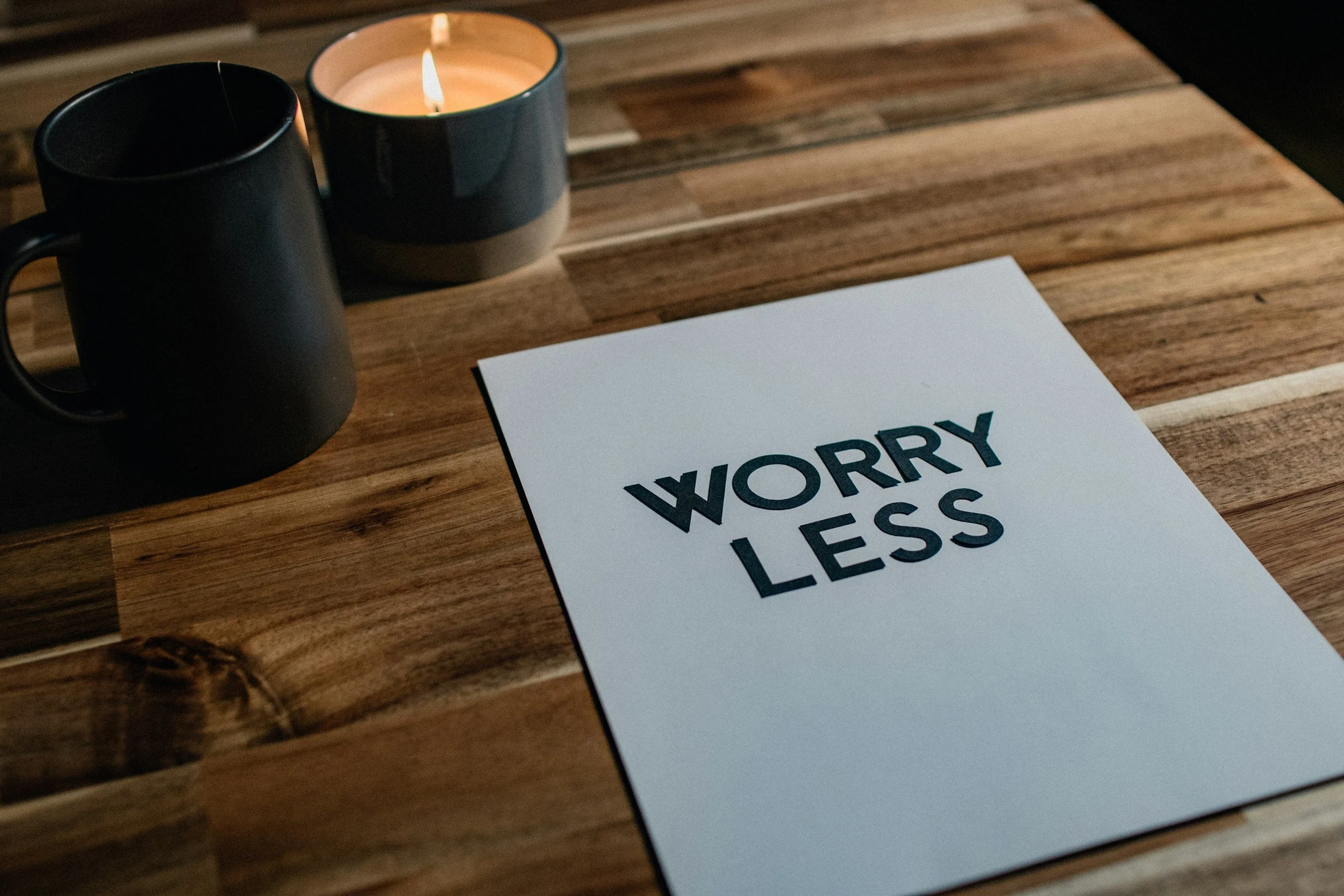 Sign saying worry less with candle in the background