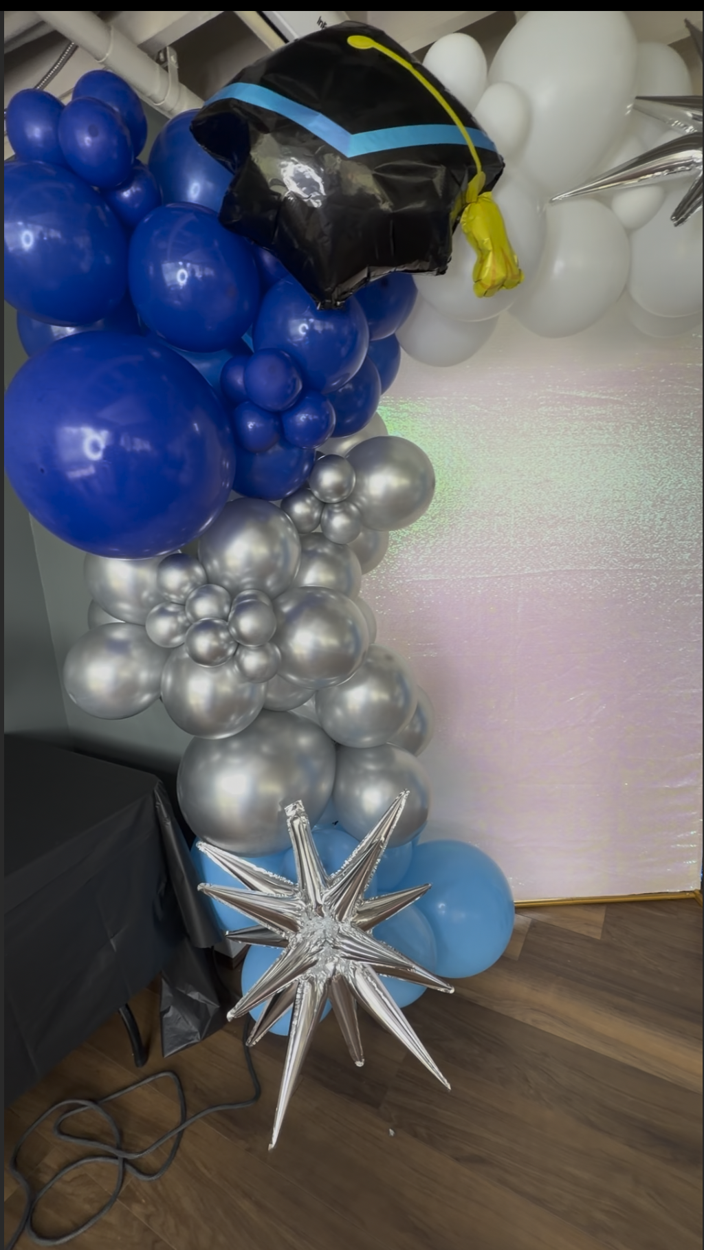 Honyes Booth Graduation Photo Booth rental set up in Hampton Roads Virginia with White, silver and different shades of blues balloon arch. 