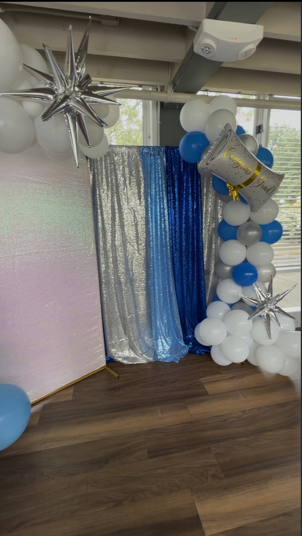 Honyes Booth Graduation Photo Booth rental set up in Hampton Roads Virginia with White, silver and different shades of blues balloon arch. 