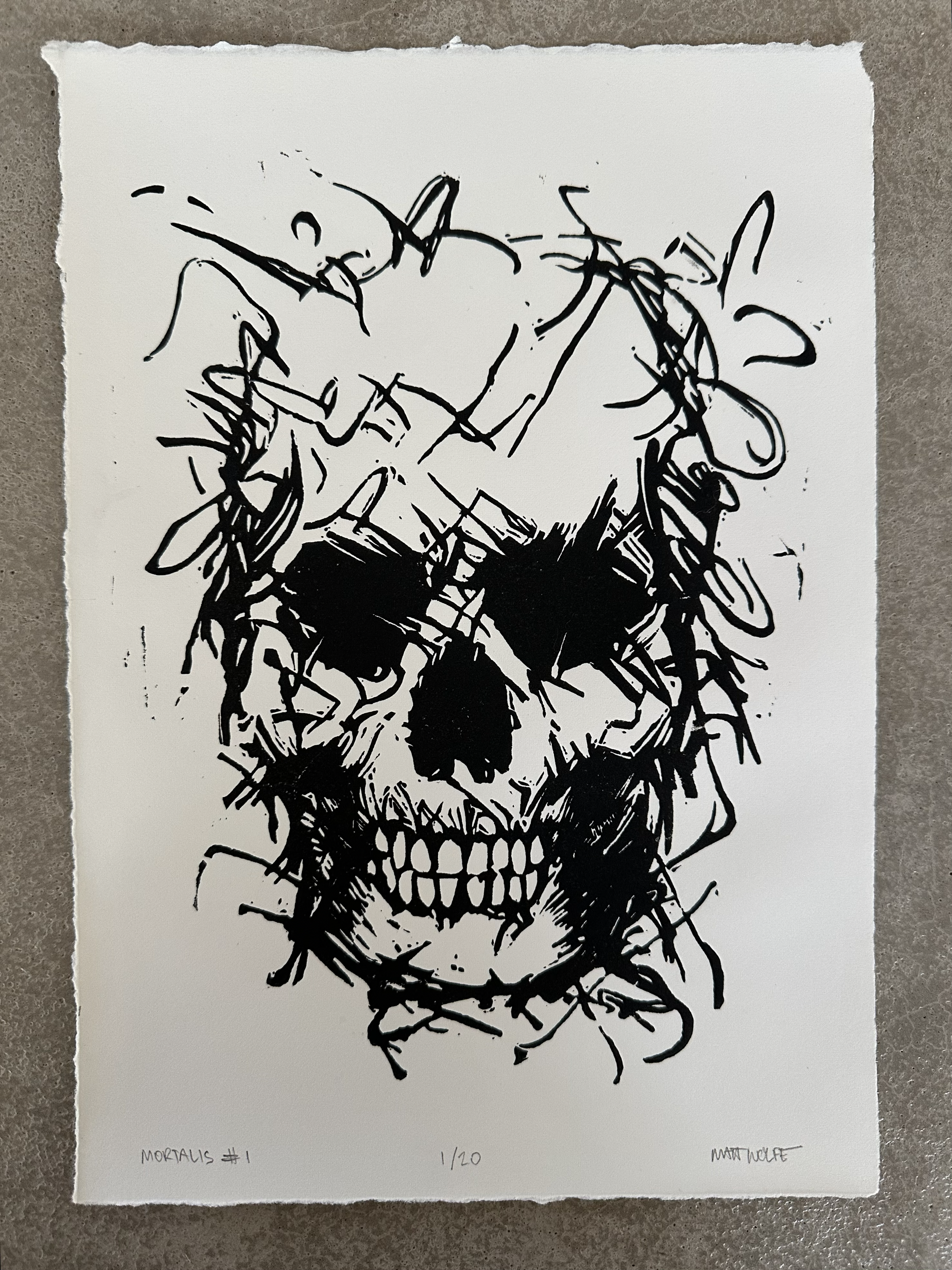 Hand-carved relief print of a human skull by contemporary artist Matt Wolfe, titled Mortalis #1, printed on textured cotton rag paper