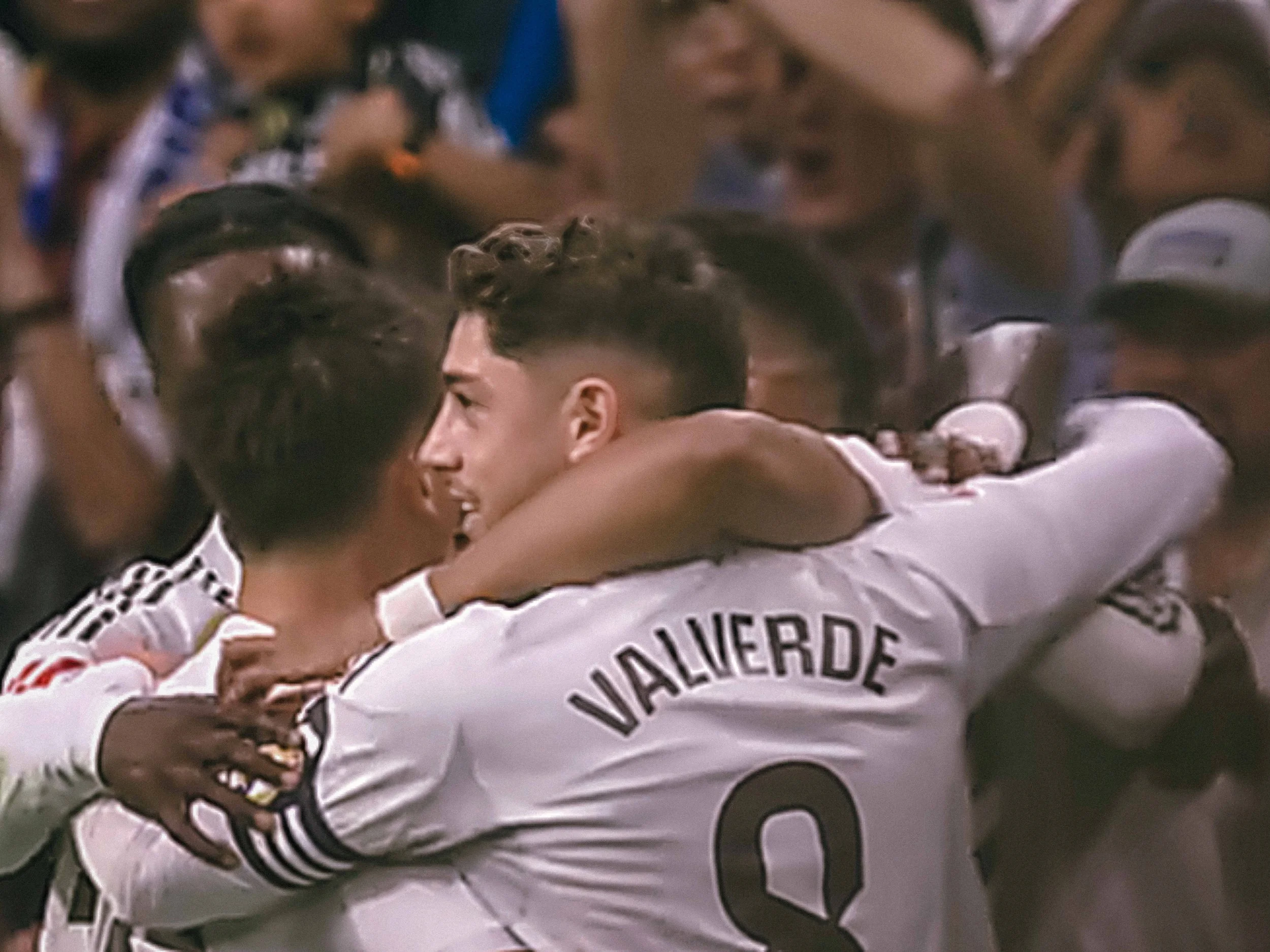 Soccer players in white jerseys embrace in celebration, with "Valverde" visible on one shirt.