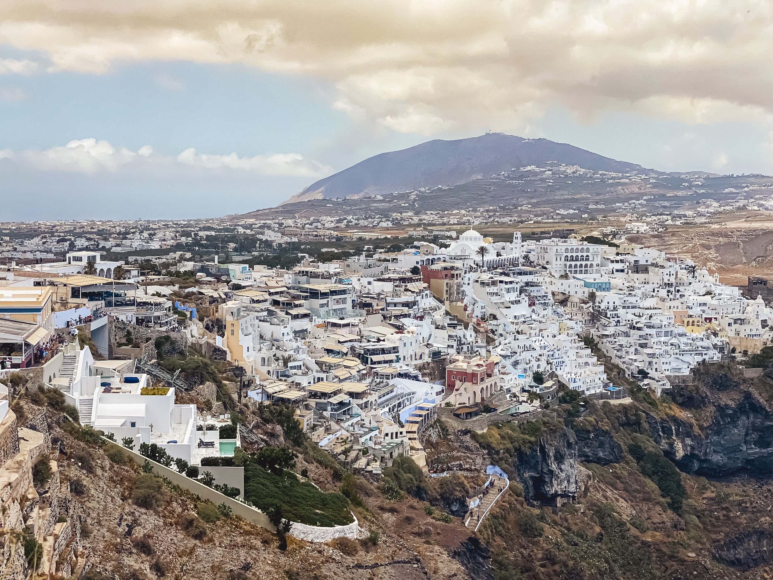 I remember standing there — heart stilled, camera poised — as Santorini unfolded like a memory I hadn’t made yet. The rooftops below, hushed in soft white, the sea beyond humming with its ancient lull.
It felt like holding stillness in my lens.
Now
