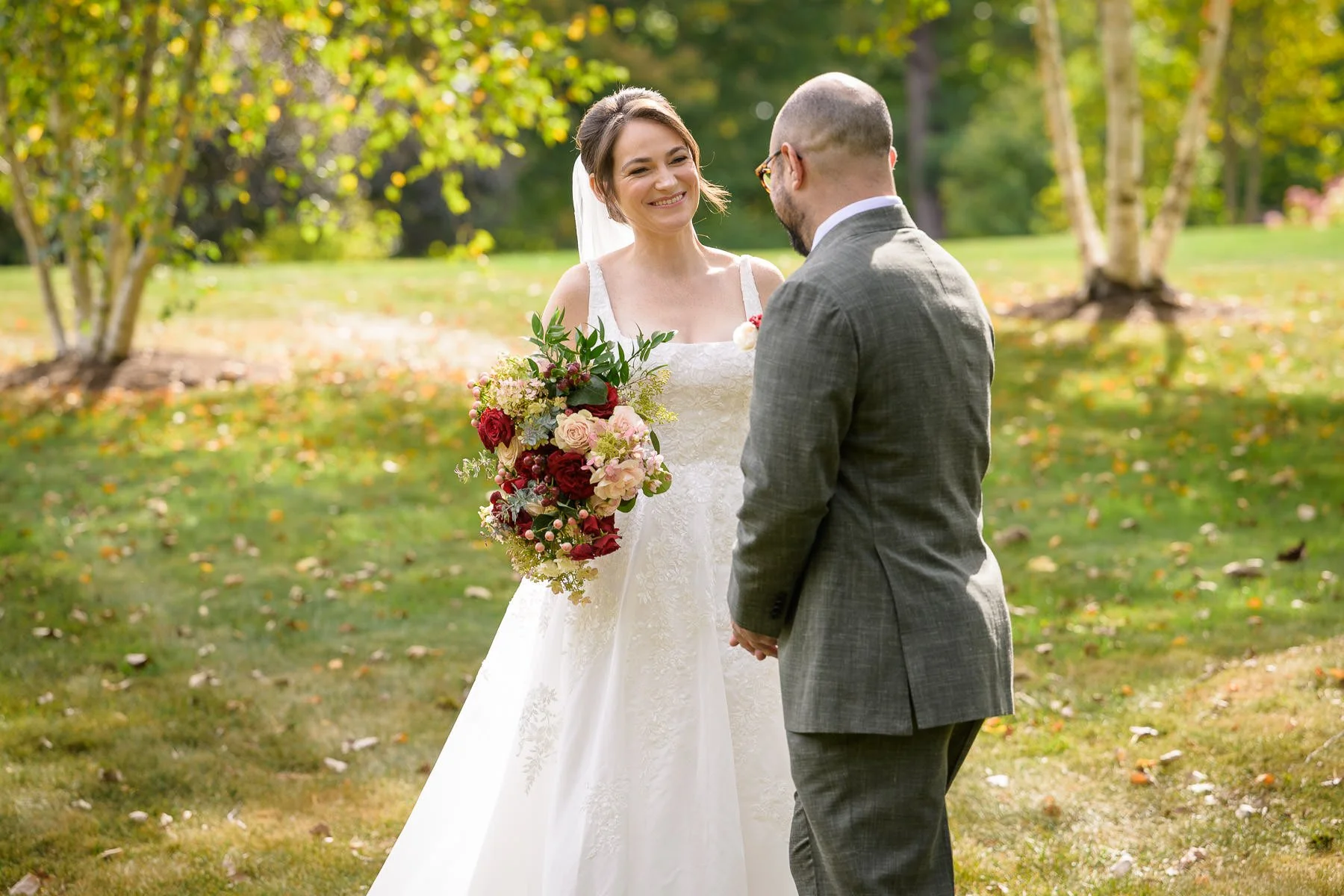 Chelsea smiles at David during their first look on the lawn at the Inn at Manchester in Vermont as they hold hands in the afternoon light. The moment captures their emotional reaction just after seeing each other.