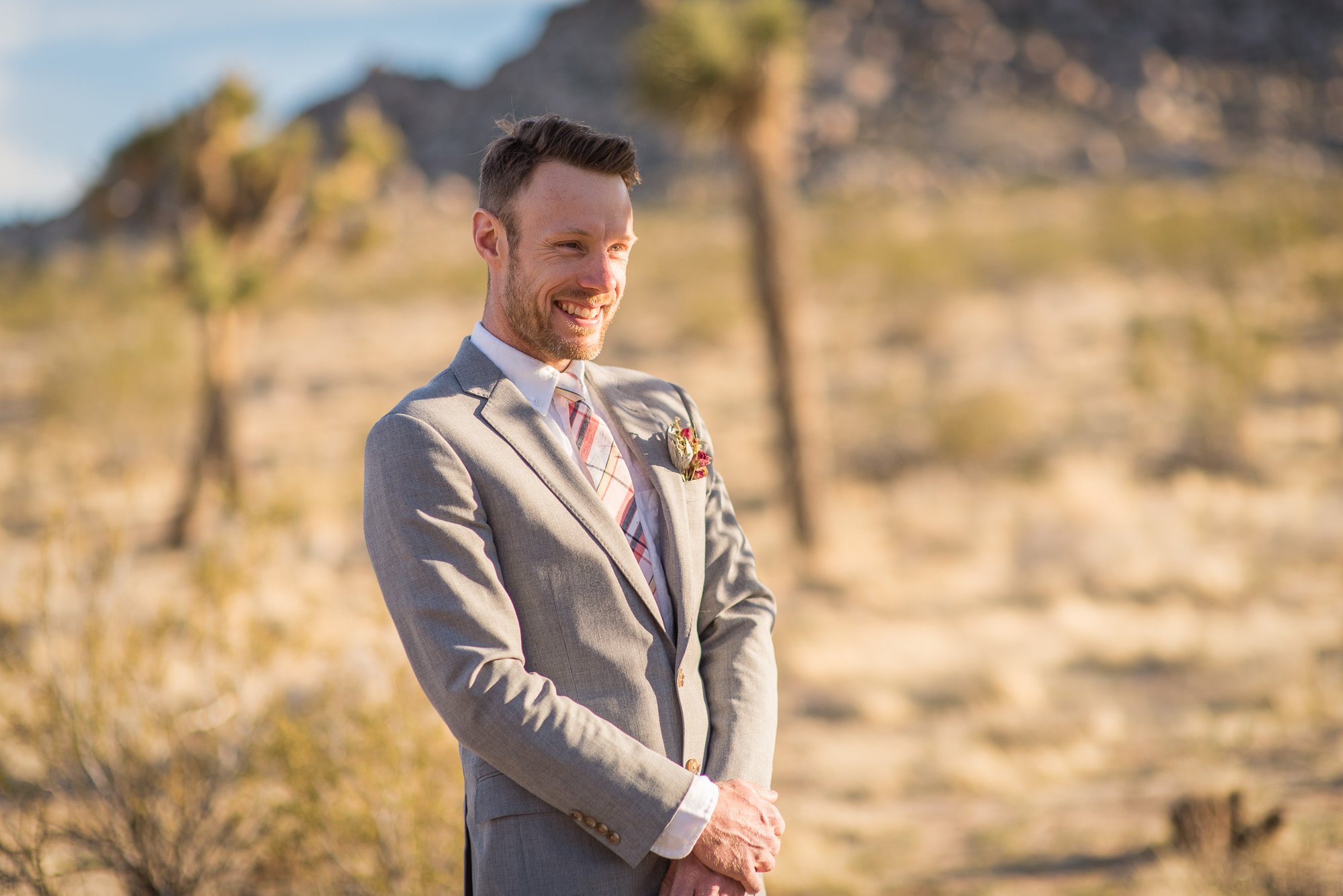 Groom smiling in golden hour light among Joshua Trees