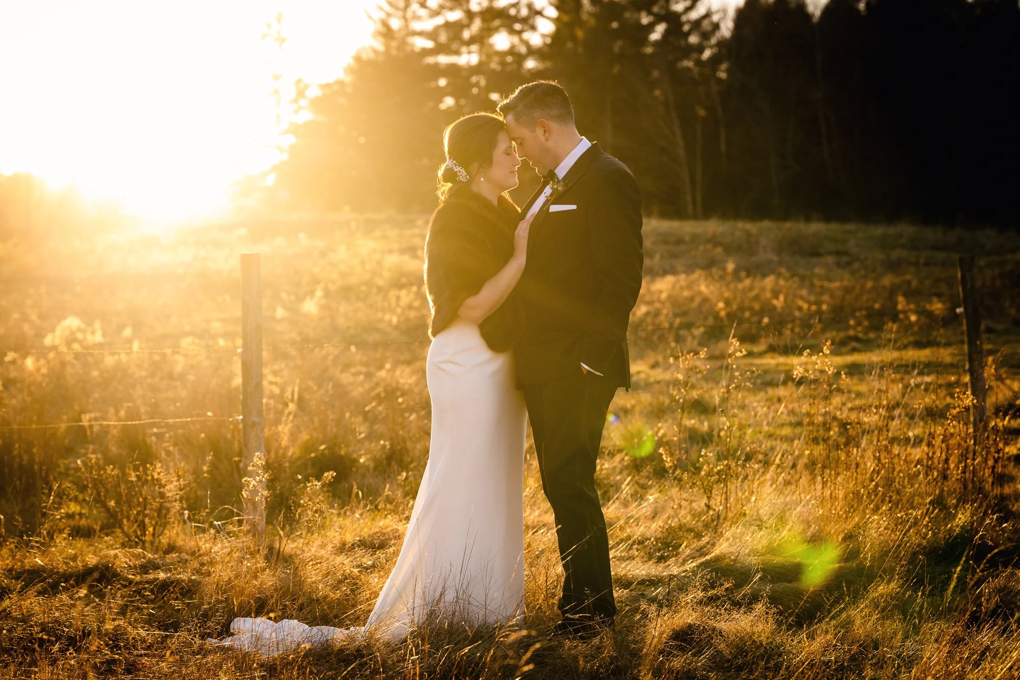 Bride and groom sharing an intimate moment during golden hour wedding portraits at The Inn at Round Barn Farm in Waitsfield, Vermont