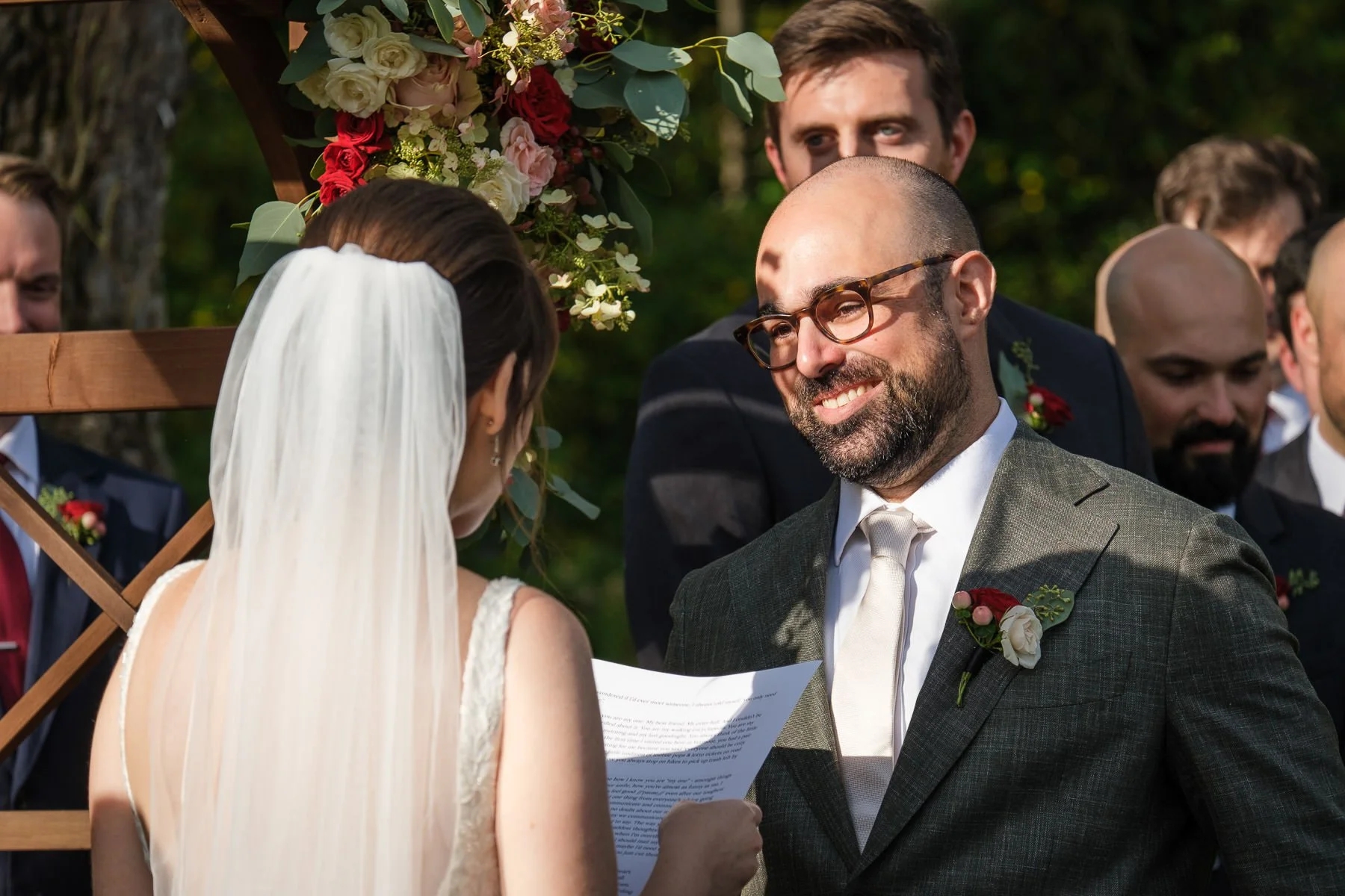 David smiles at Chelsea while she reads her vows during their outdoor wedding ceremony at the Inn at Manchester in Vermont.