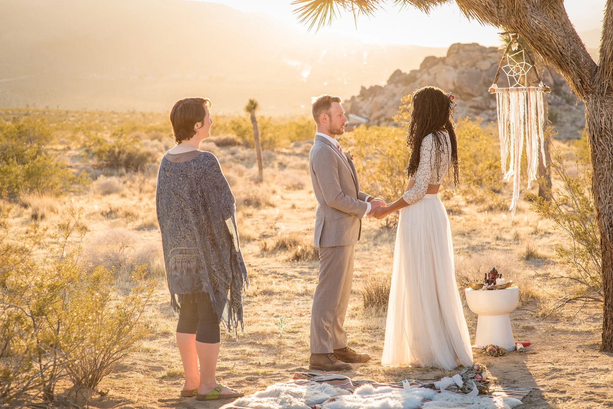 Couple begins ceremony beside macramé altar at their Joshua Tree desert elopement