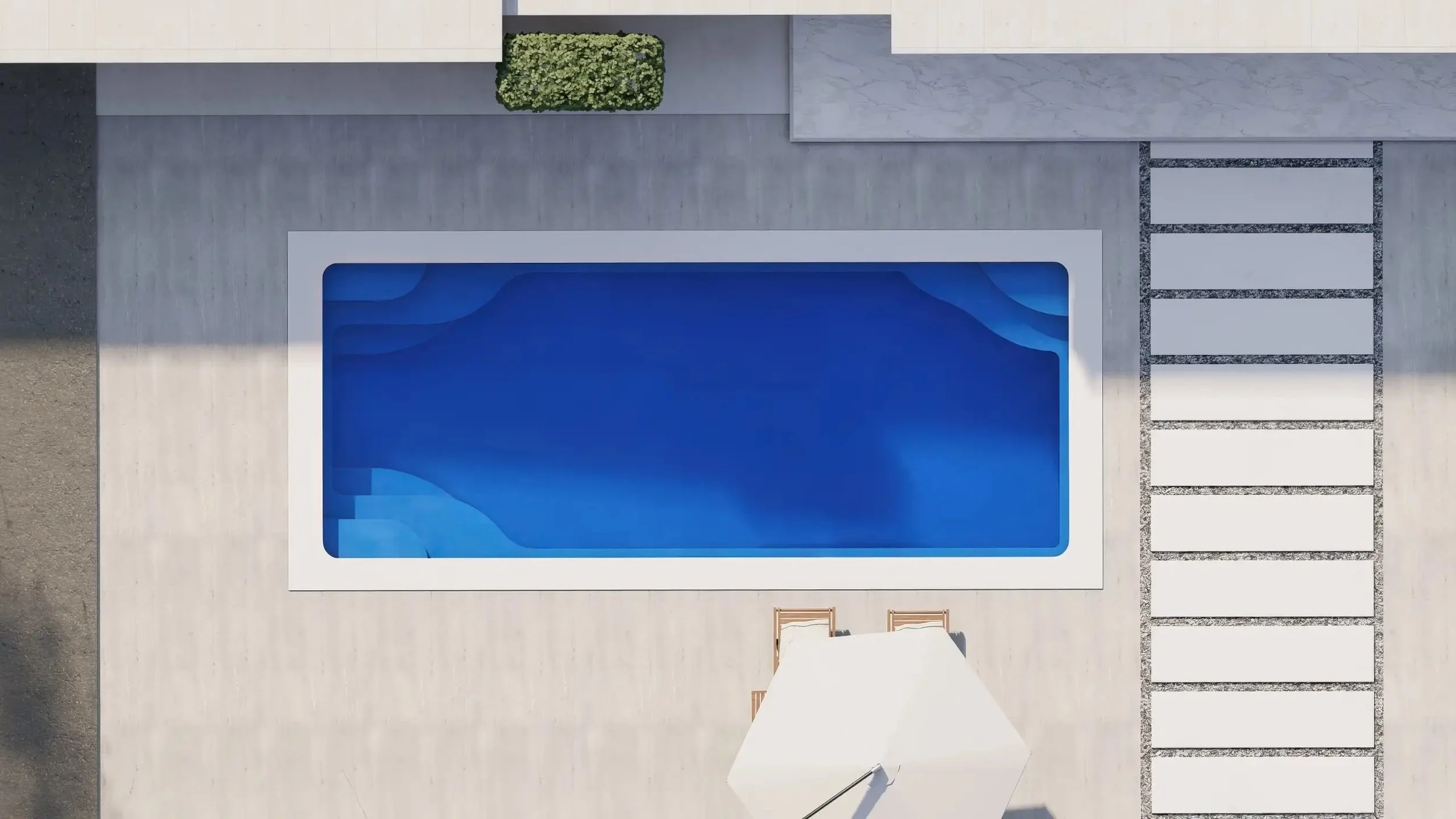 A top-down view of a modern outdoor swimming pool with blue water, surrounded by a light-colored deck, a small green hedge, and a white umbrella with two wooden chairs.