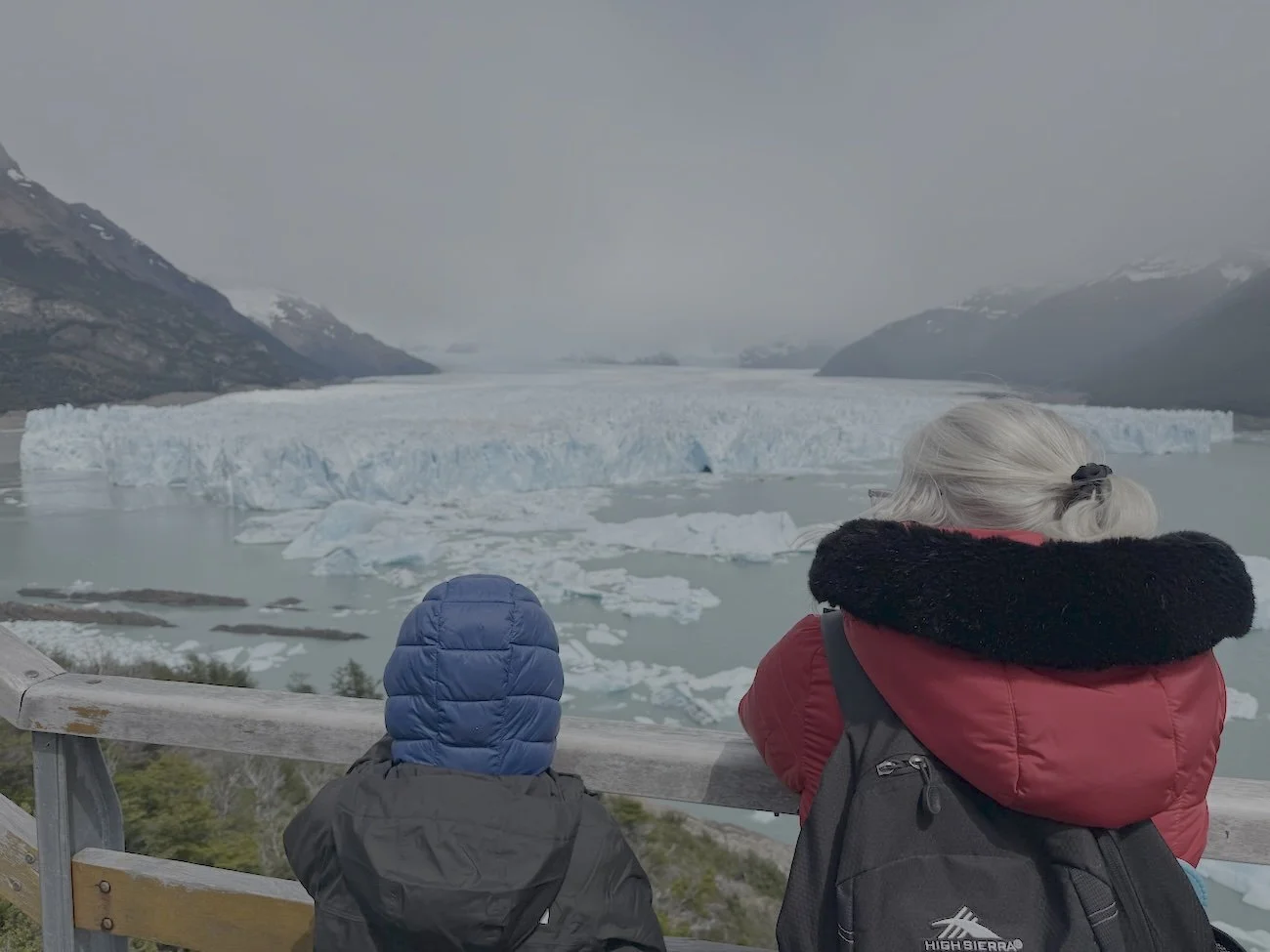 A child and his grandmother look out at Perito Moreno Glacier in Patagonia, Argentina.