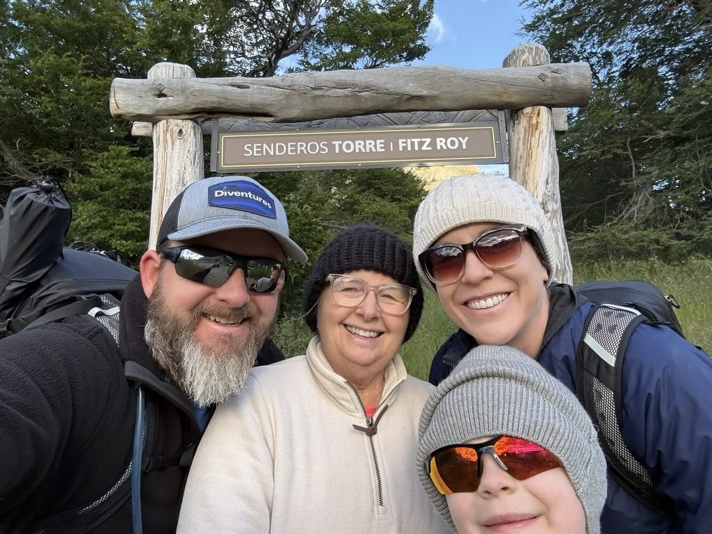 Family of four at the Fitz Roy trailhead before hiking toward Laguna de los Tres in El Chaltén, Patagonia, Argentina.