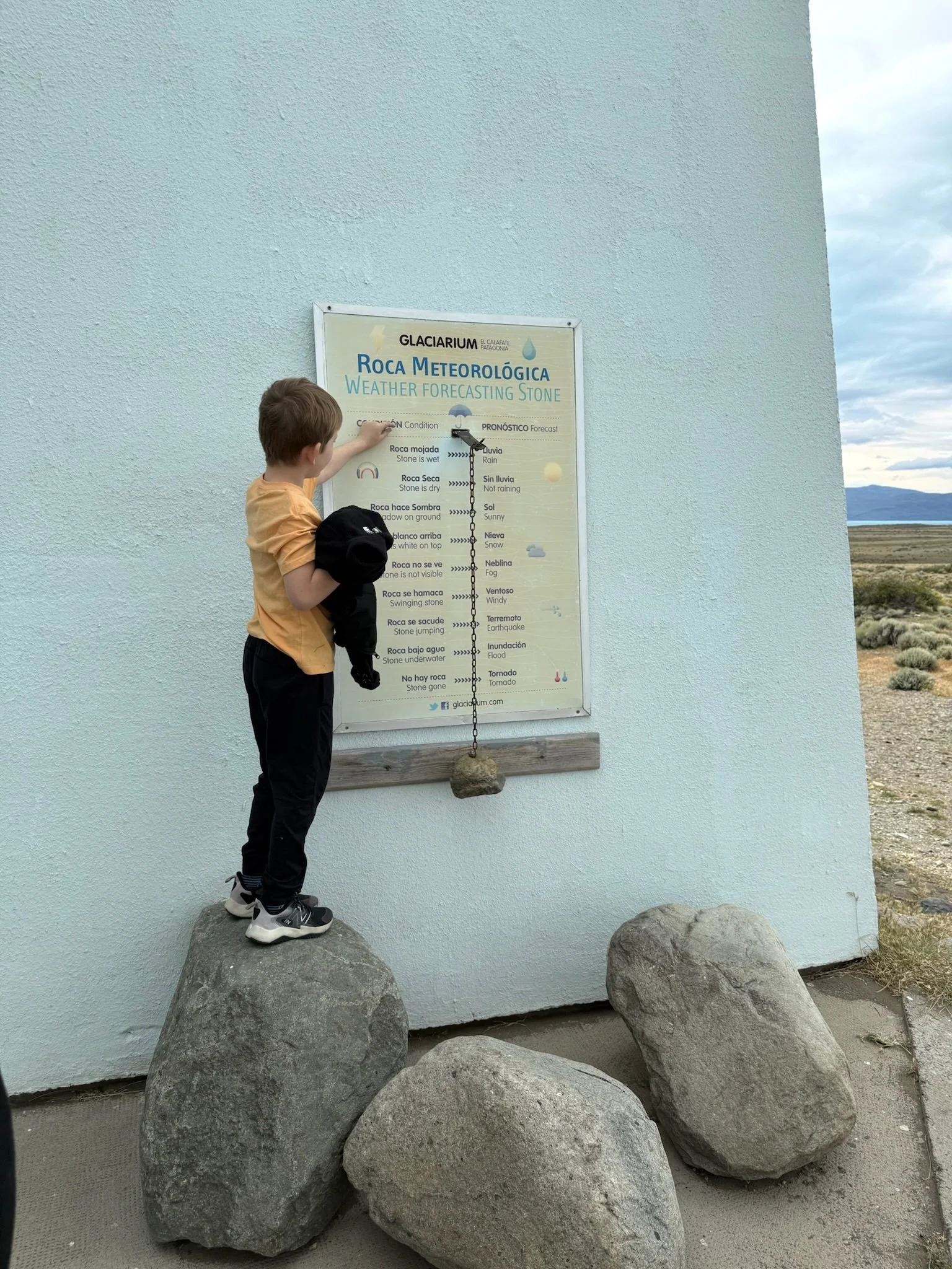 Child pointing at a weather forecasting stone display outside the Glaciarium in Patagonia, Argentina.