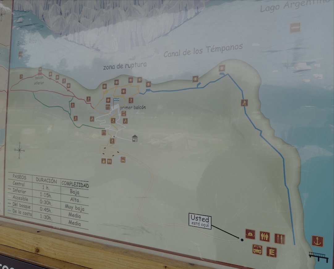 Trail map sign at Perito Moreno Glacier showing color-coded walking routes, viewing balconies, and the Canal de los Témpanos along Lago Argentino.