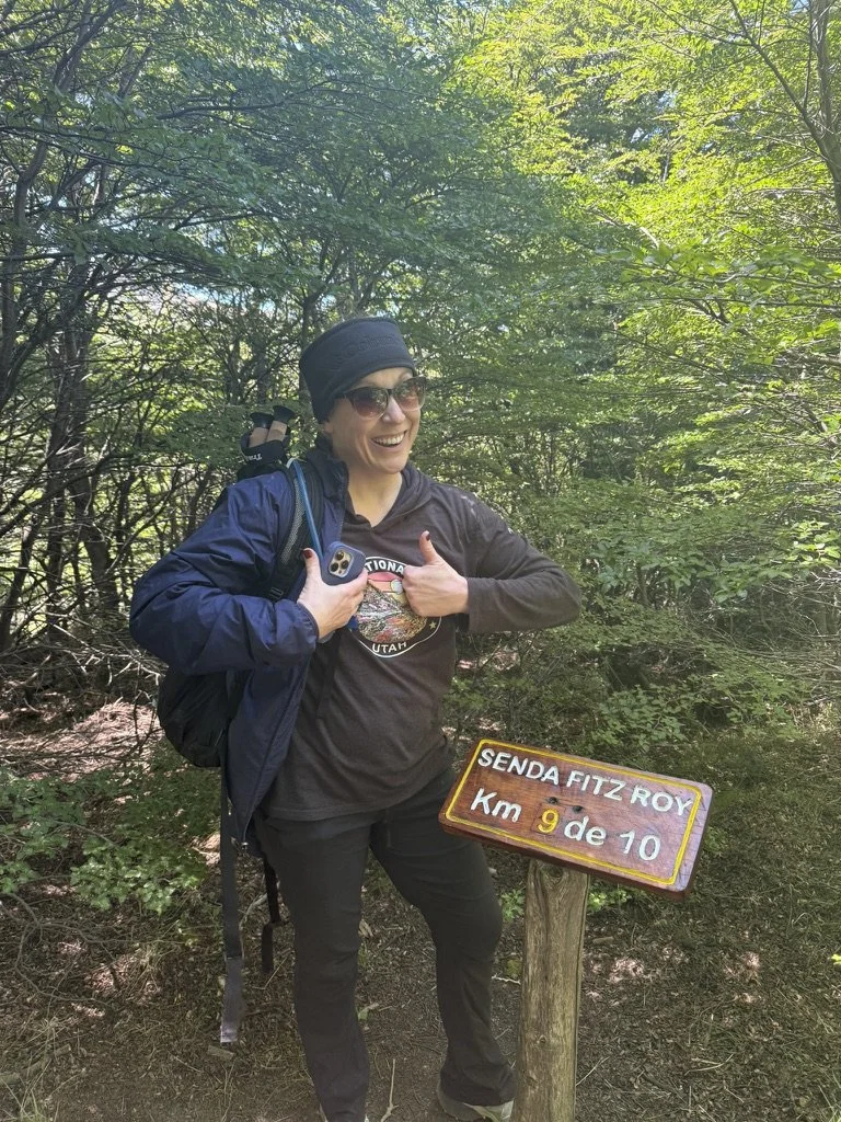 Hiker standing beside the kilometer 9 of 10 trail marker on the Fitz Roy trail before the final climb to Laguna de los Tres.
