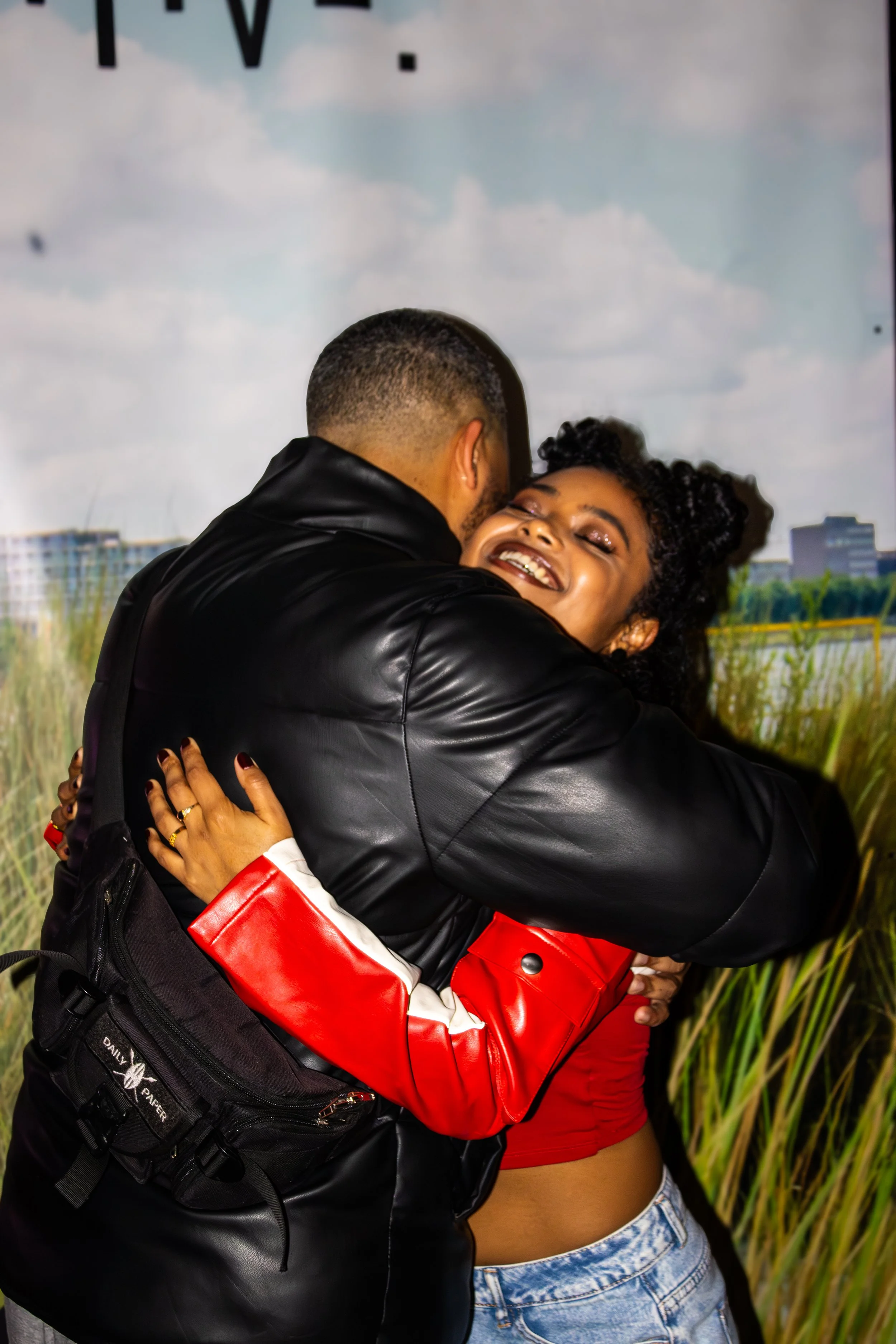 A couple embracing and smiling with a scenic nature background.