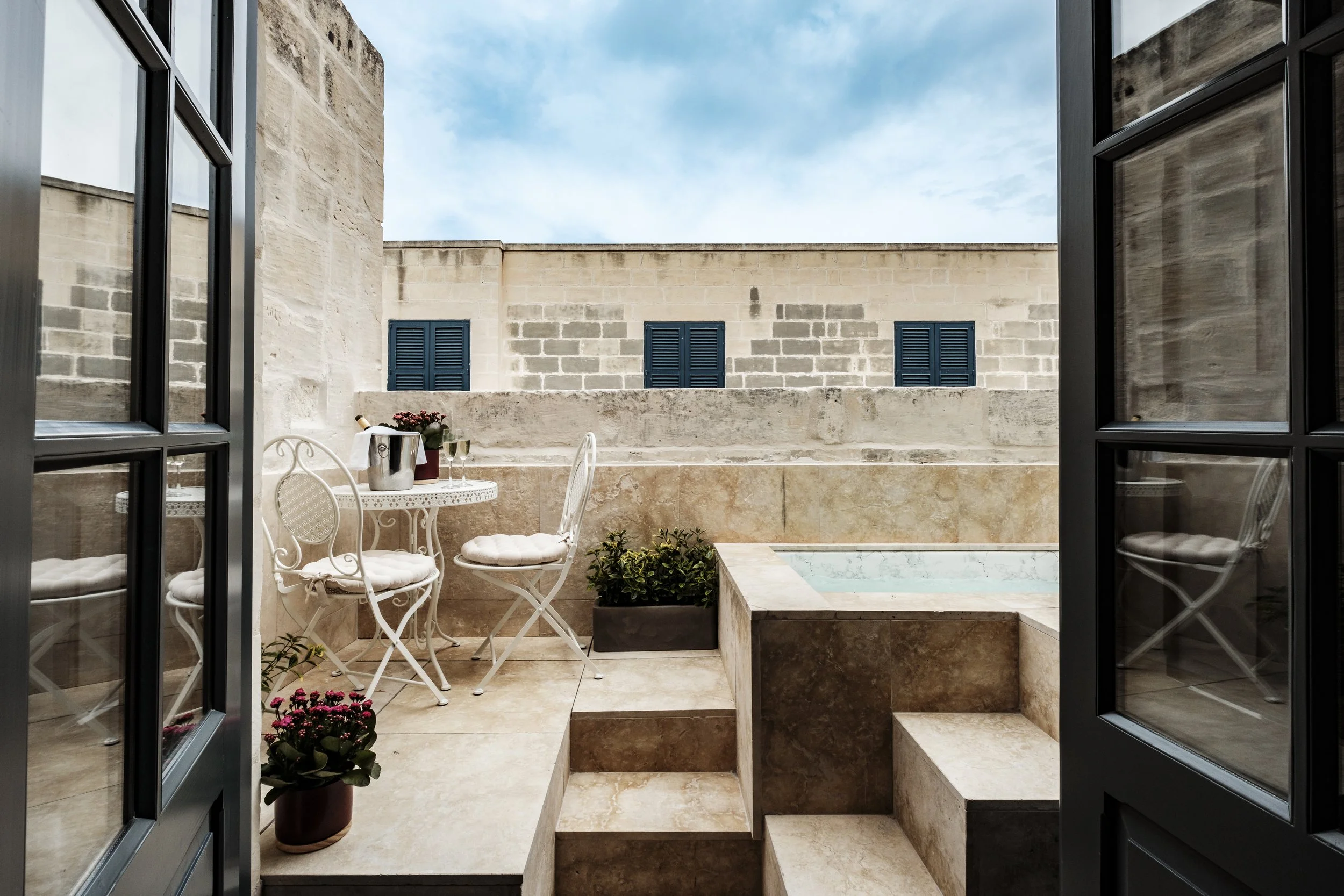 PREMIUM SUITE WITH A HOT TUBE - An elevated suite offering a private terrace with outdoor hot tub and open views over Valletta, designed for immersive moments of privacy and refined indulgence.