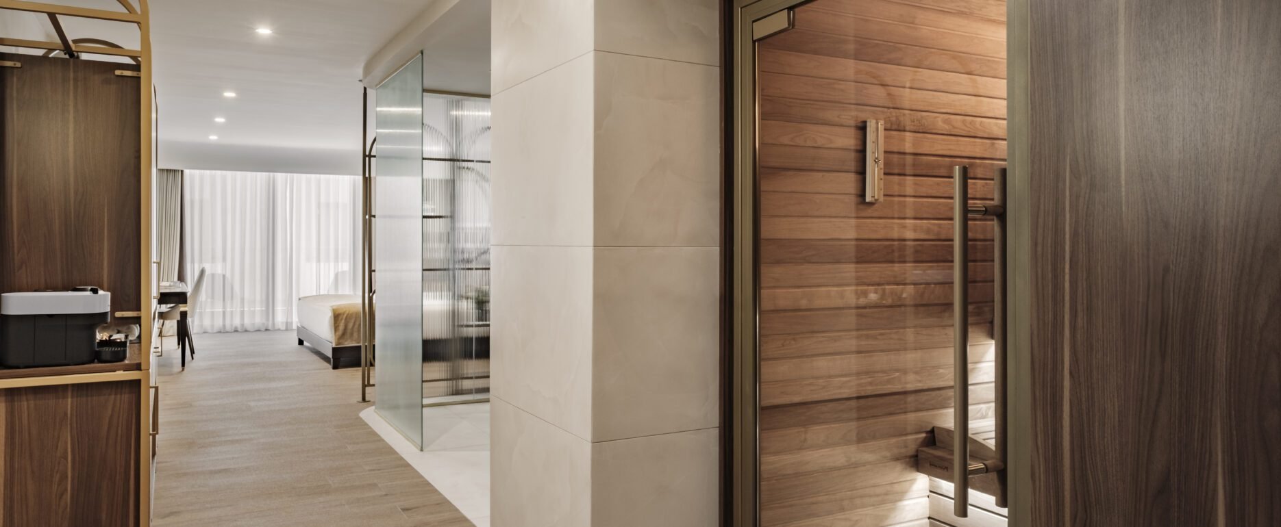 DELUXE SUITE WITH PRIVATE SAUNA - A refined wellness suite featuring a private sauna and a serene atmosphere designed for restoration and quiet relaxation.