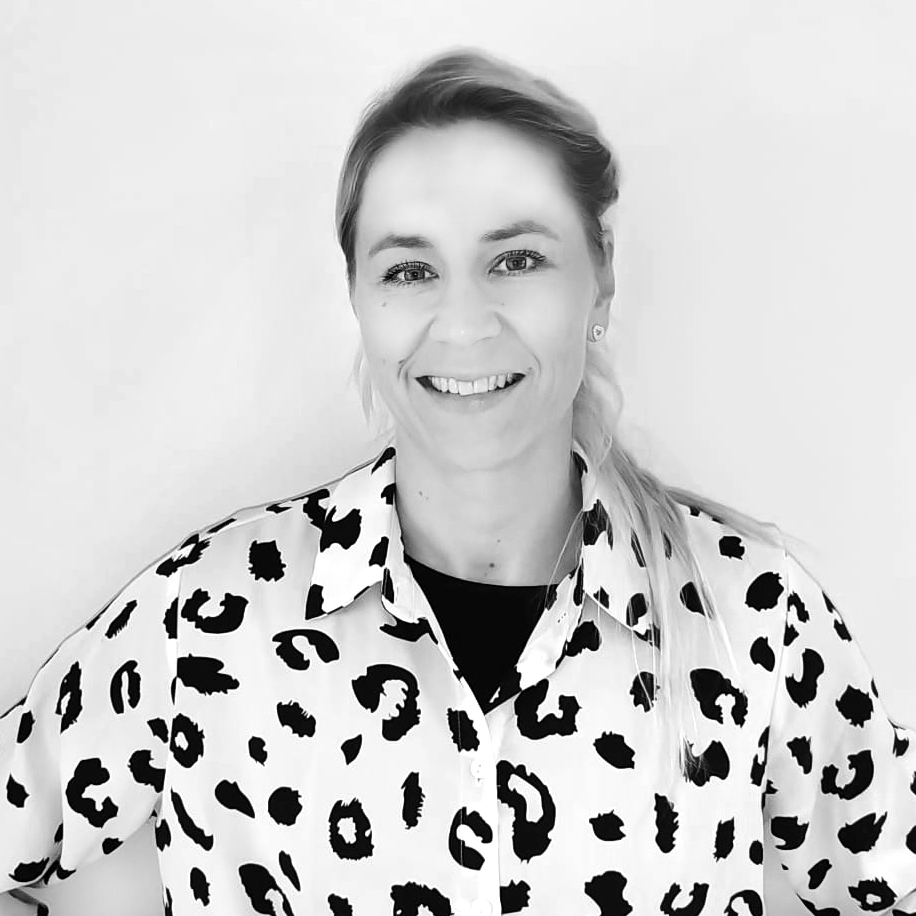 Vasema ihmisen kasvokuva, nainen hymyilee, vaaleat hiukset, paita, jossa villieläinten kuvio.