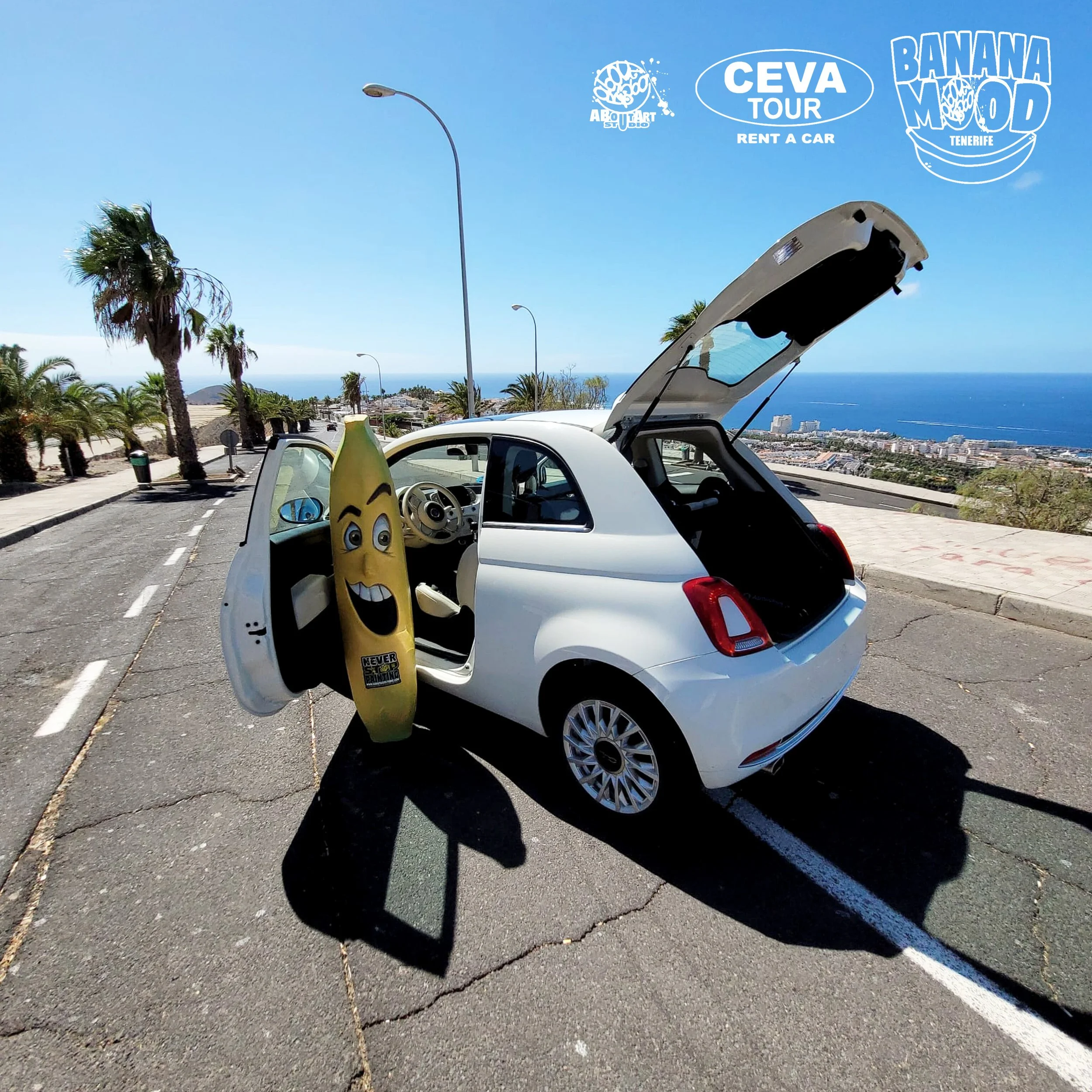 Coche blanco con puerta y maletero abiertos en una zona costera, con una banana inflable con cara feliz en la puerta. En la esquina superior derecha, logos de CEVATOUR, Banana Mood y About Art Studio.