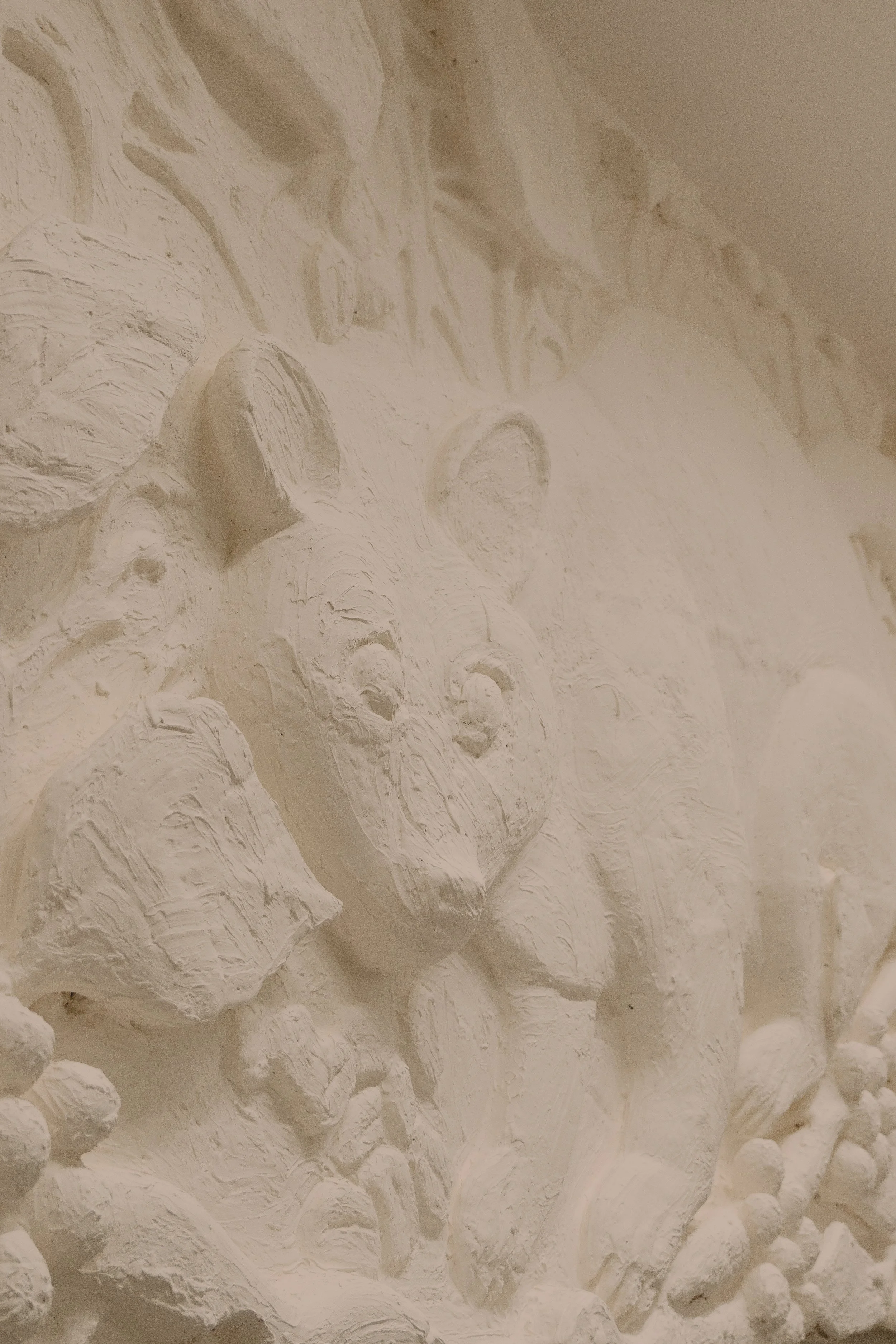 Relieve en color blanco de un león con detalles en relieve.