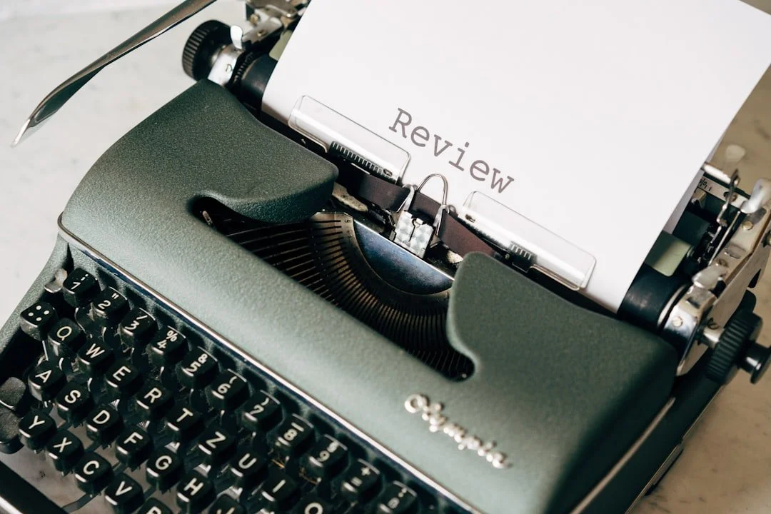 A vintage green typewriter with a sheet of paper that has the word 'Review' typed on it. For reviews for shoulder pain and stress and anxiety.