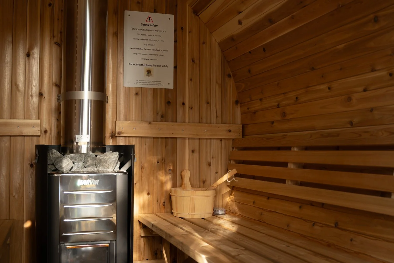 Warm and inviting sauna interior showing natural cedar wood and glowing stove, part of Sauna On Location’s mobile wellness offerings in Rhode Island.