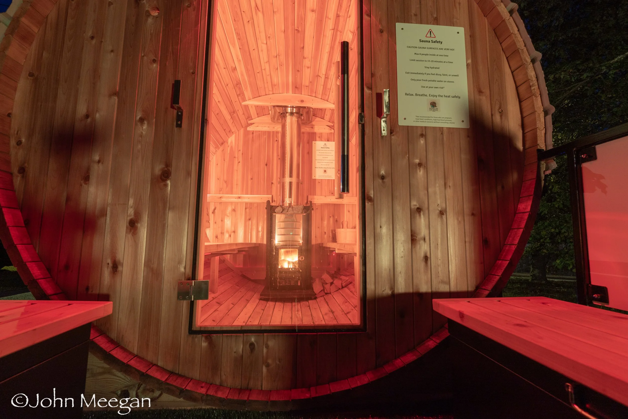 Interior view of cedar barrel sauna glowing with warm light, handcrafted and delivered by Sauna On Location in South County RI.