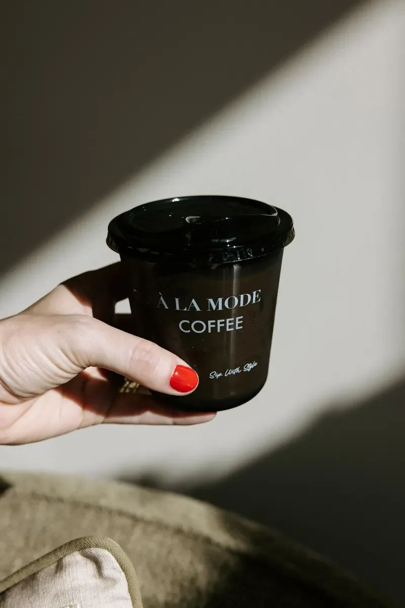 A coffee moment captured during SkinPharm’s grand opening celebration, with a signature À LA MODE COFFEE cup.