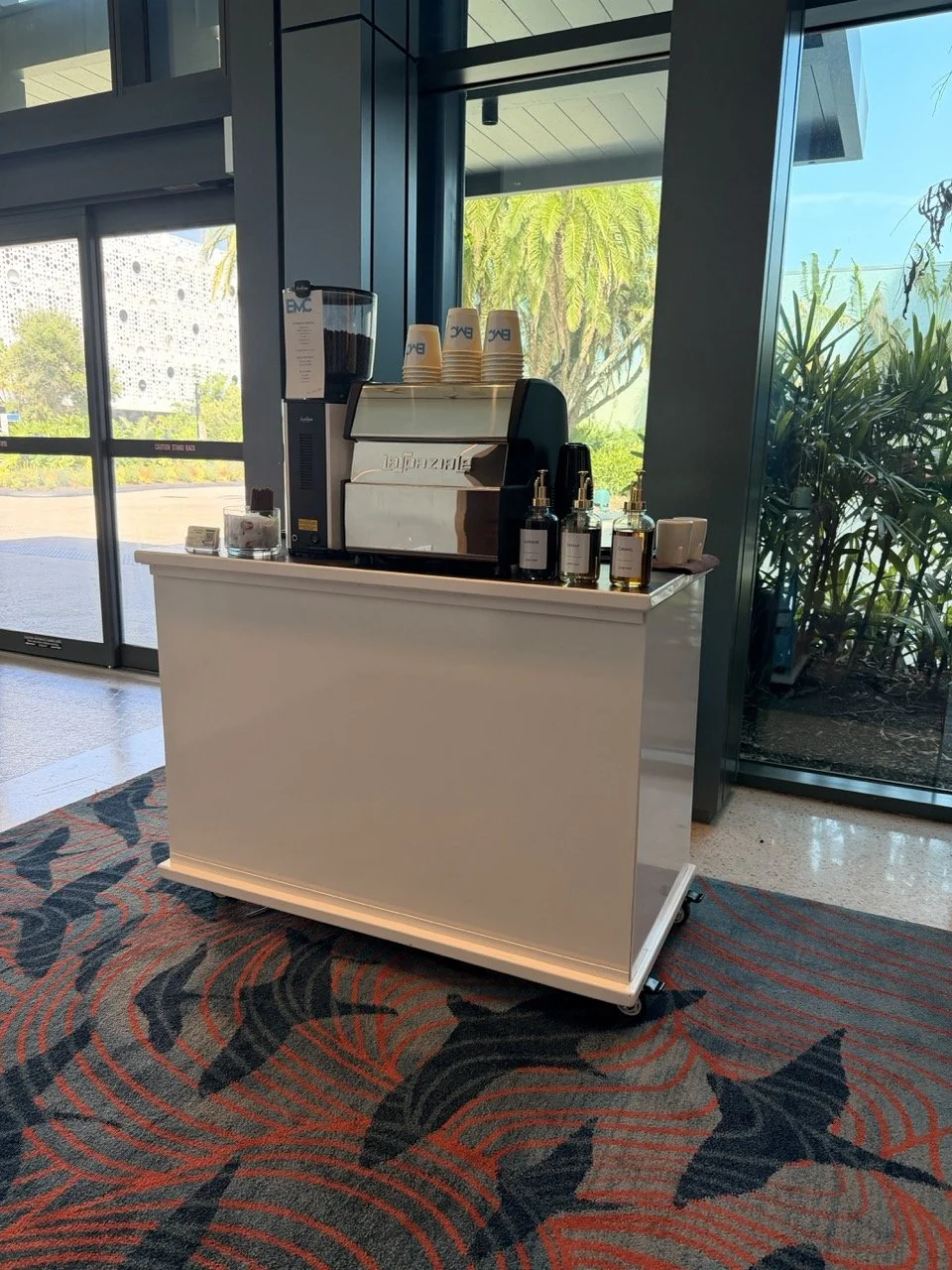 Luxury coffee cart with custom company branding providing handcrafted espresso drinks during a private event. À La Mode Coffee delivers exceptional coffee catering with personalized menus, branded carts, and premium coffee experiences for every occas