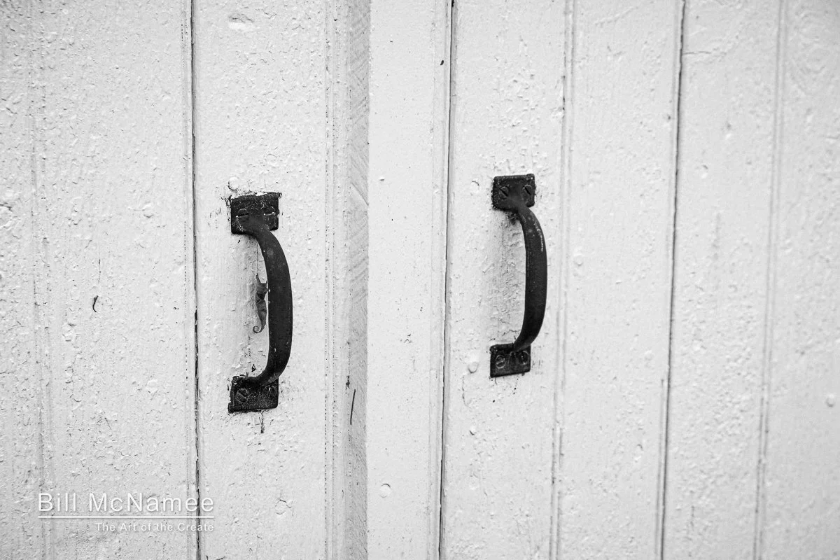 Weathered metal handles mounted on white wooden barn doors in Westminster, Maryland