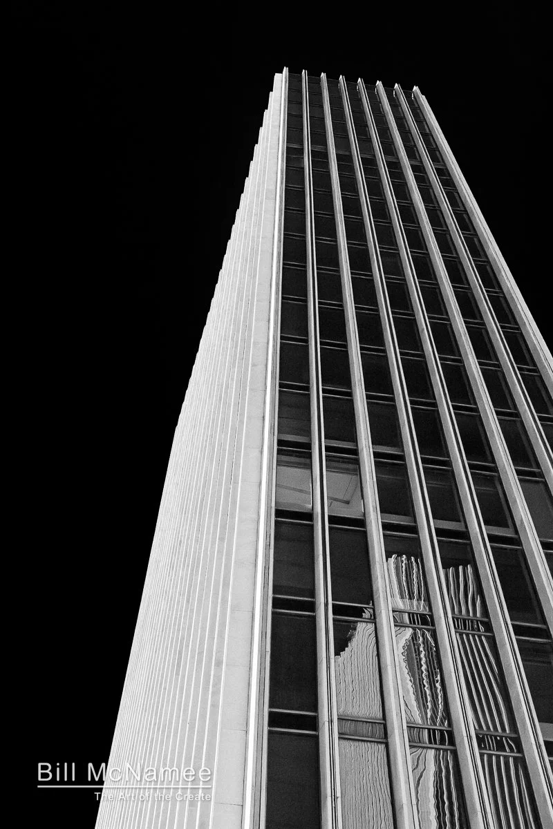 Low angle black and white view of Empire State Plaza buildings in Albany, New York with converging vertical lines