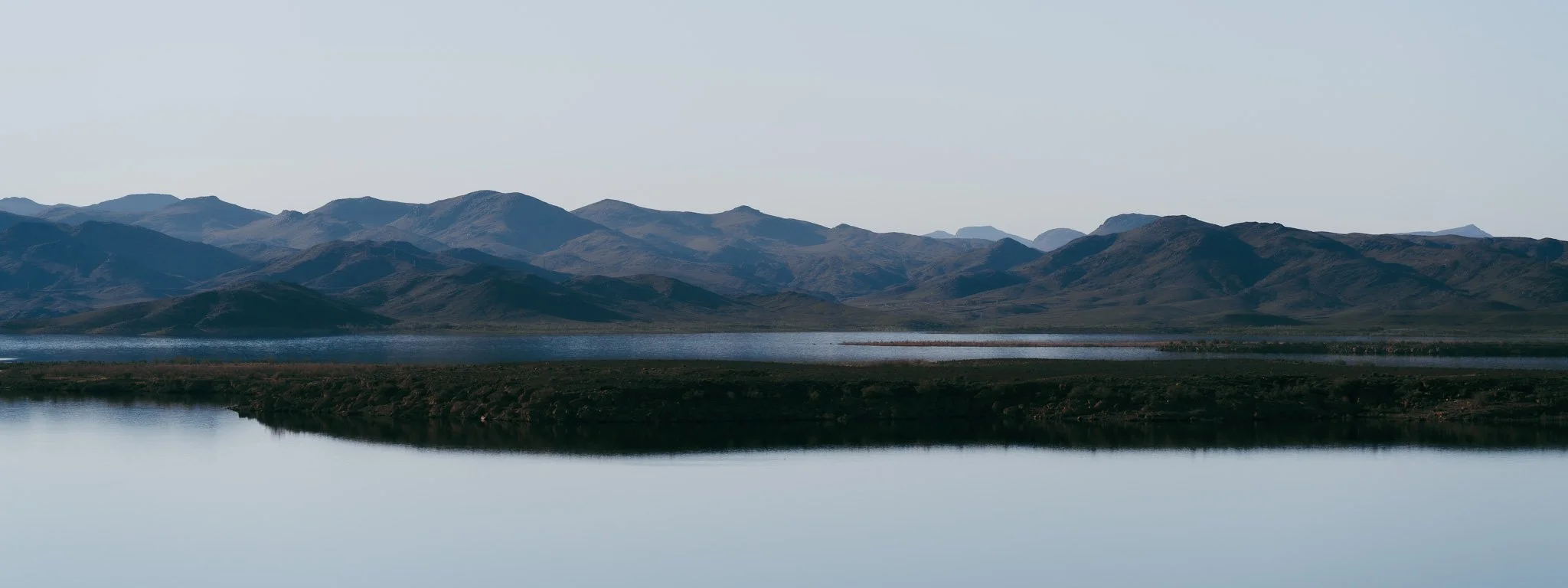 Landschaft mit Bergen, Wasser und Ufer, klare Himmel