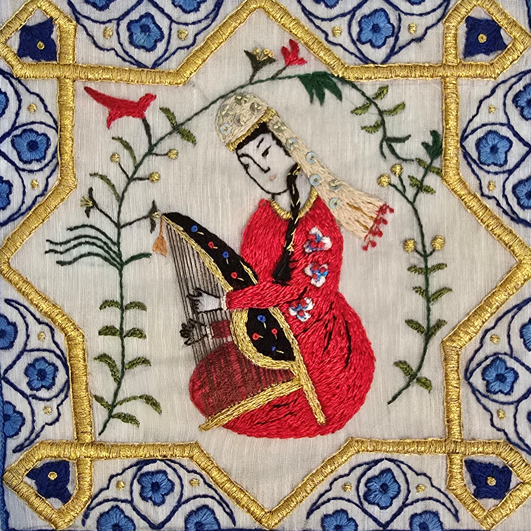 Embroidery of a woman in traditional attire playing a stringed instrument, surrounded by floral patterns and a decorative star-shaped border.