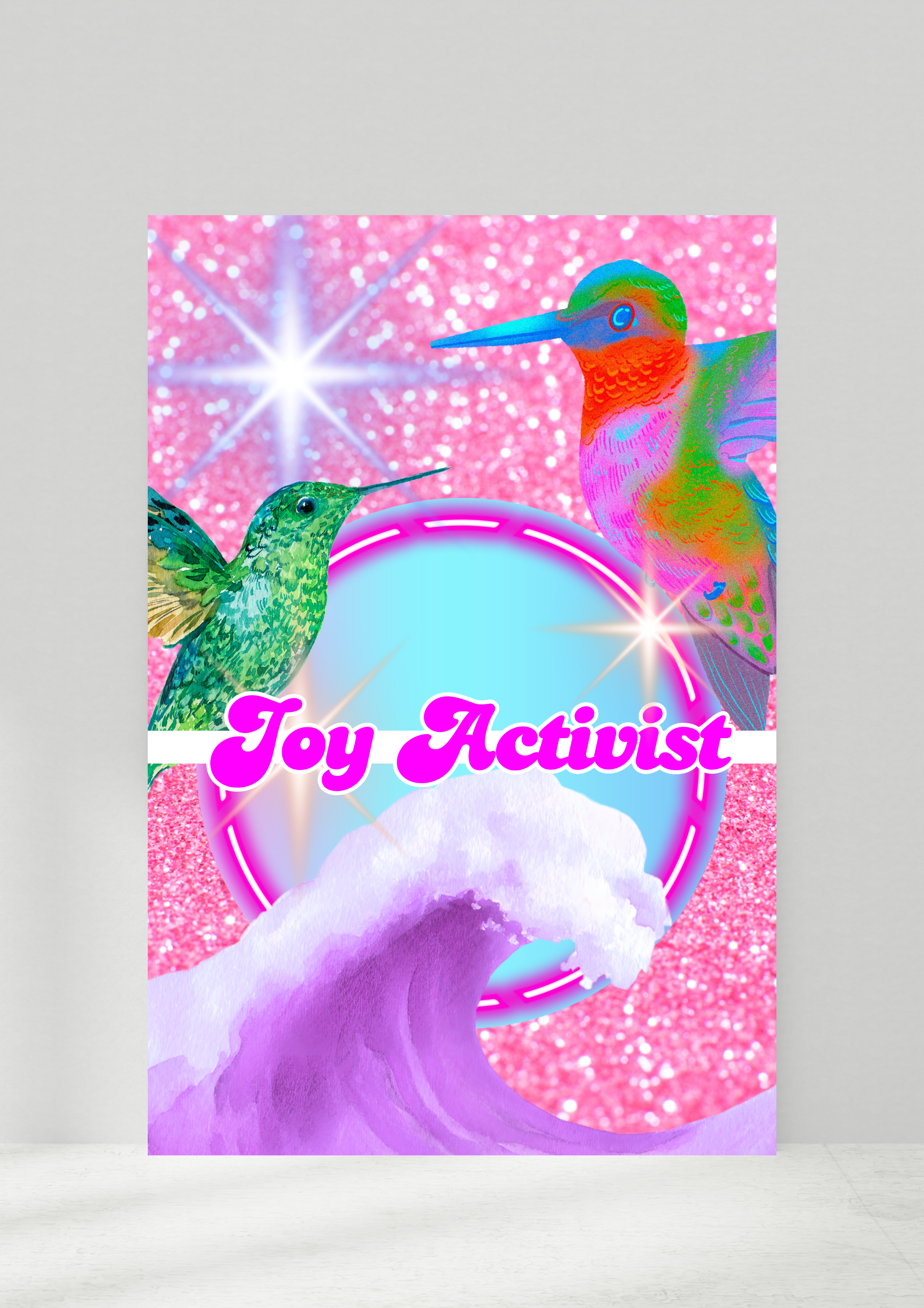 Colorful artwork featuring two hummingbirds with vibrant rainbow feathers, pink glittery background, glowing circular design, and the words 'Joy Activist' in pink cursive font.