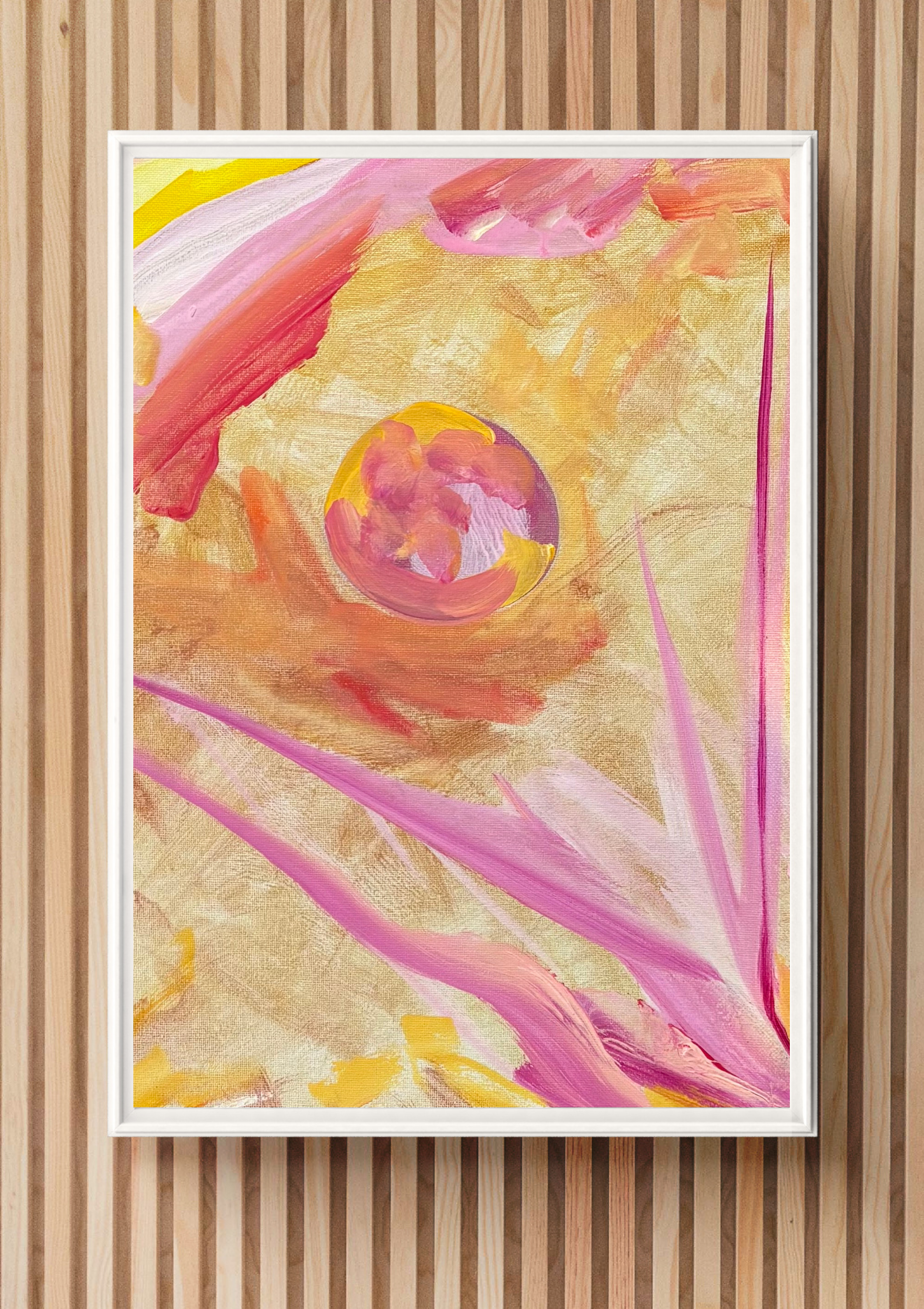 An abstract painting with pink, yellow, and red brushstrokes on a golden background, framed with a white border, hanging on a wooden wall.