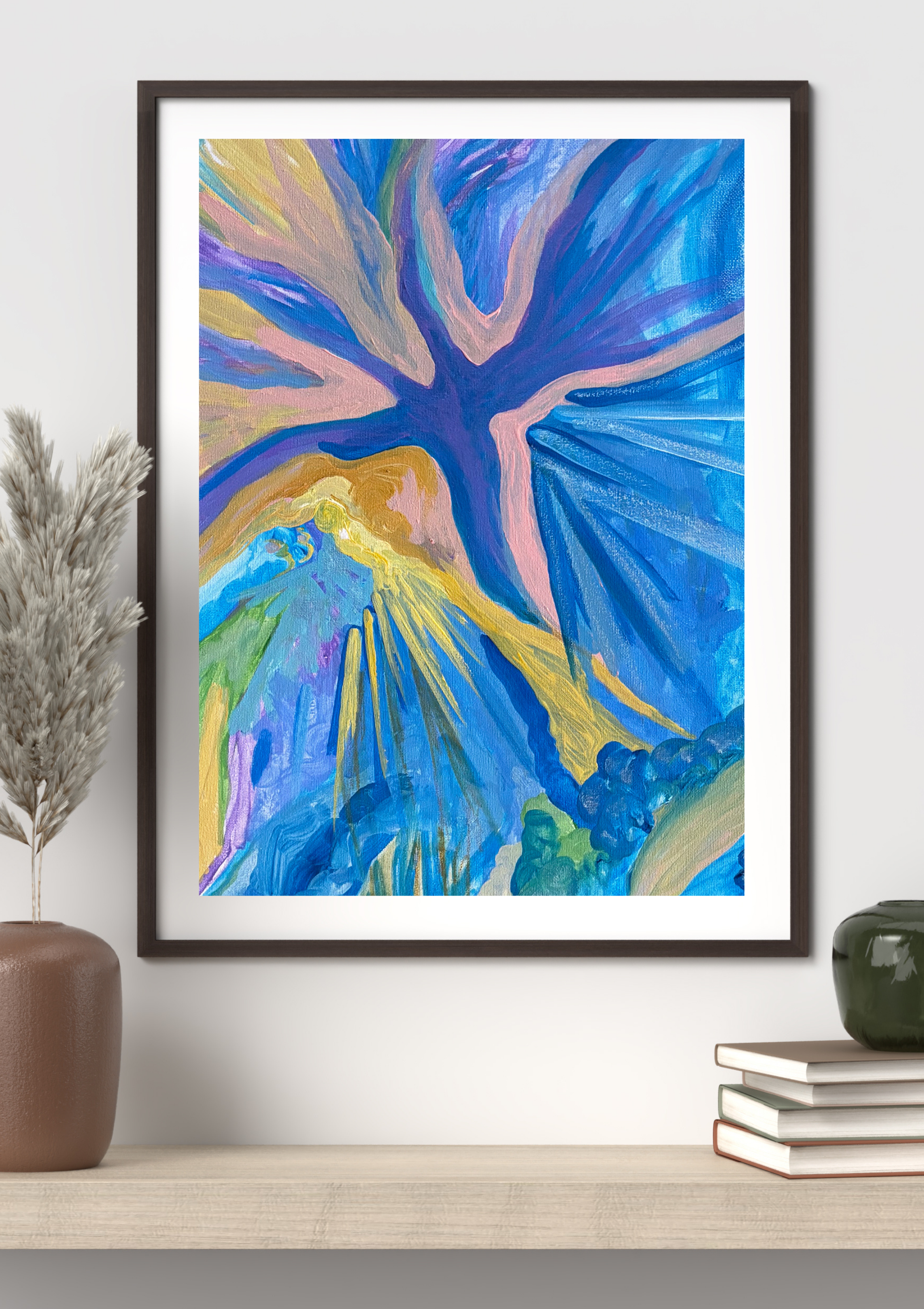 An abstract colorful painting of a tree with blue, purple, pink, yellow, and green hues, framed and hung on a white wall, with a side view of a brown vase with dried plants on the left, and a stack of books and green vase on the right.