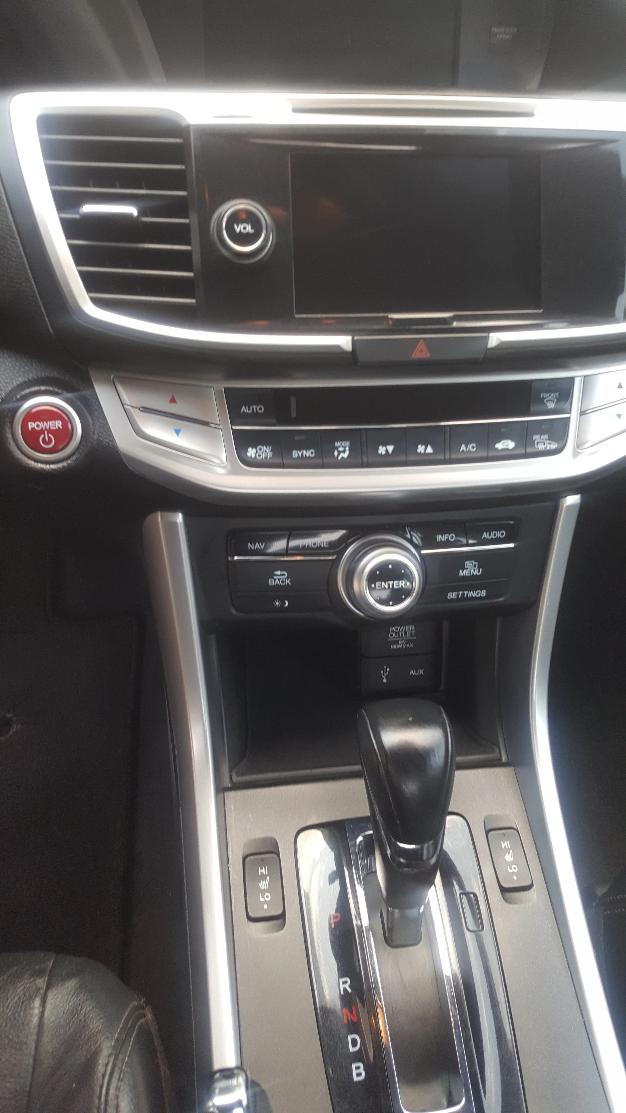 Interior of a car showing dashboard, steering gear shift, and control buttons