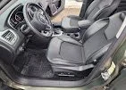 Interior view of a vehicle's front passenger side, showing the seat, door, and dashboard.