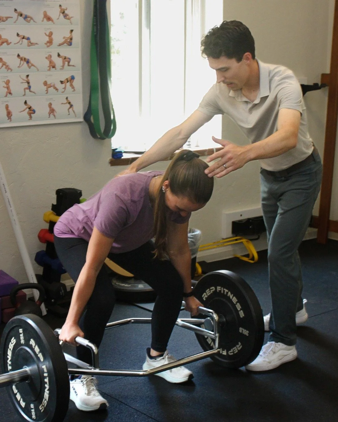 Sports chiropractor coaching a patient through a barbell deadlift during a rehab session at CB Movement Co. in Crested Butte, Colorado.