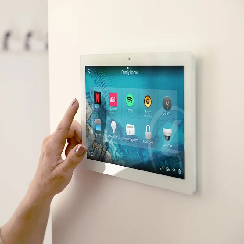 Person interacting with a wall-mounted smart home control panel in a family room.