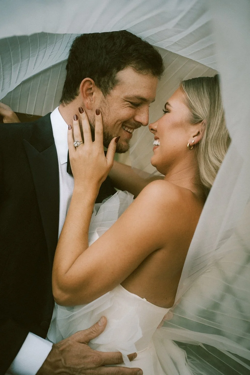 charleston-ryder-hotel-wedding-couple-smiling-hugging-under-veil-carly thompson photography.jpg