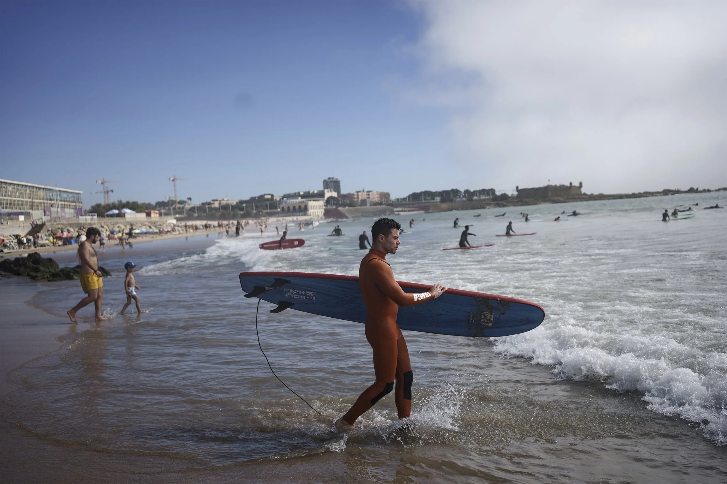 Surf Church’s pastor, the Rev. Samuel Cianelli, walks into the Atlantic Ocean to surf with his congregation in Matosinhos beach in the suburbs of Porto, Portugal on Sunday, Aug. 18, 2024. (AP Photo/Luis Andres Henao)