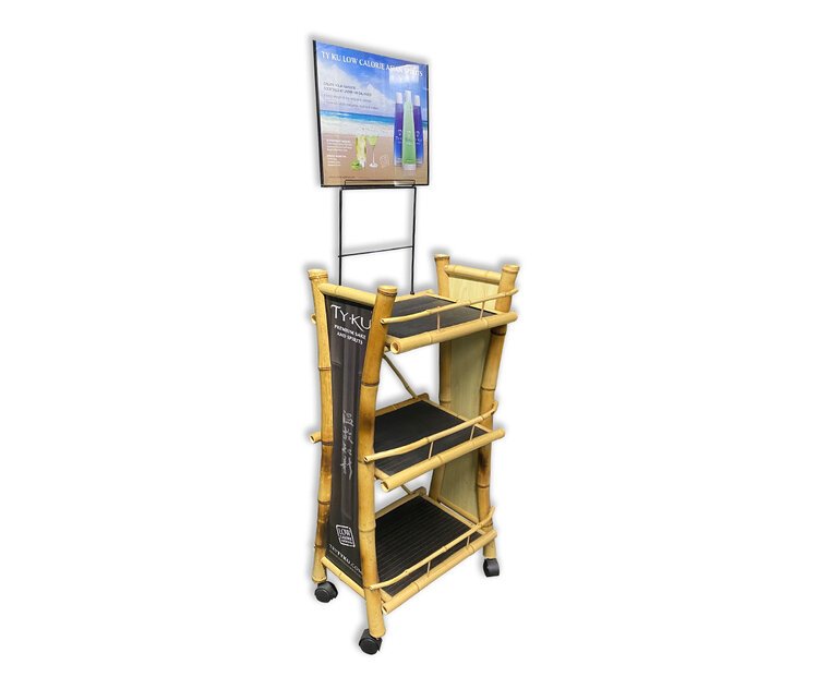 A multi-level wooden display stand with black shelves and wheels, used for retail product promotion, featuring a large board on top with advertisements.