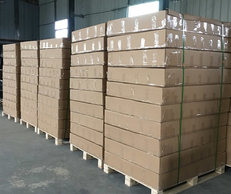 Stacks of cardboard boxes on wooden pallets inside a warehouse.