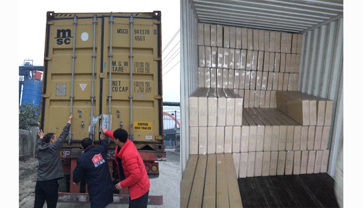 People inspecting a yellow shipping container with wooden planks or blocks inside a storage unit or container.