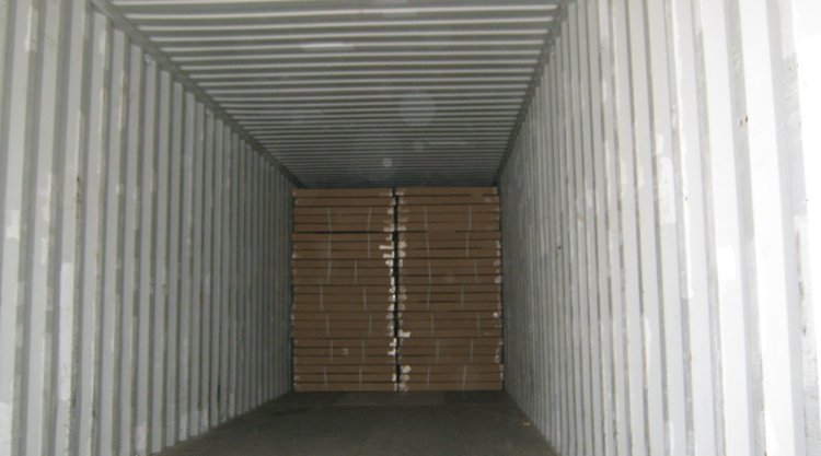A shipping container filled with stacked cardboard boxes.