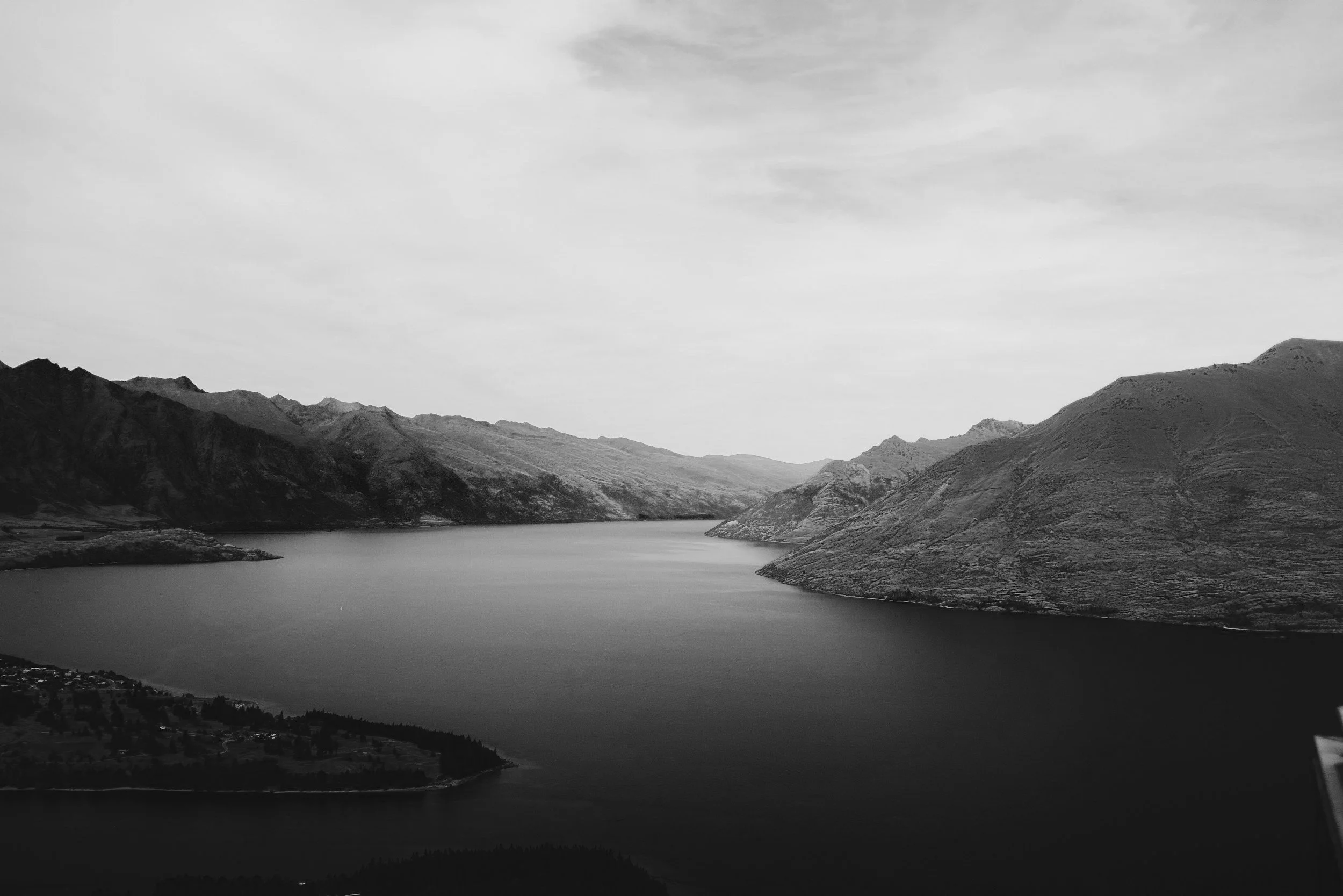 a mountain range in the distance, along water