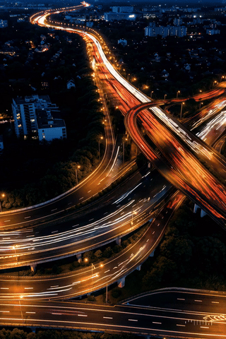Night view of a brightly lit highway interchange with light trails from moving vehicles