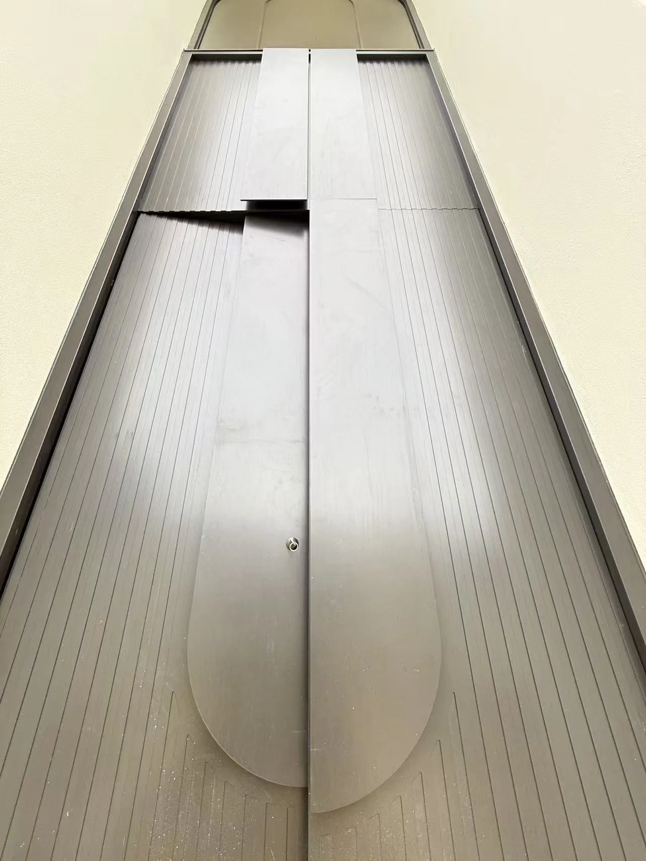 Elevator with closed metallic doors and a light-colored floor.