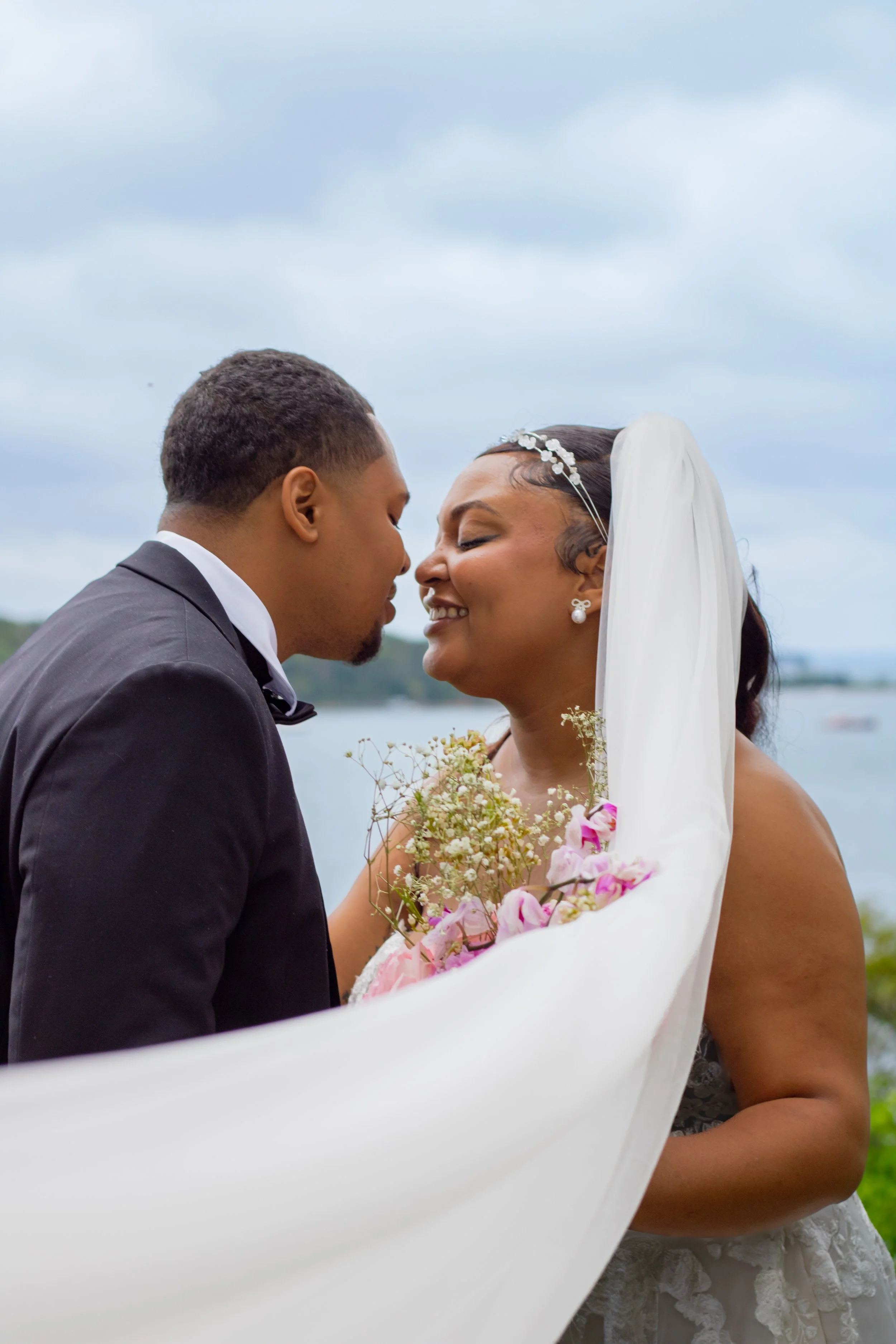 Grace Azuike's Clients, Gabrielle & Tyreke embracing by the lake on their wedding day.