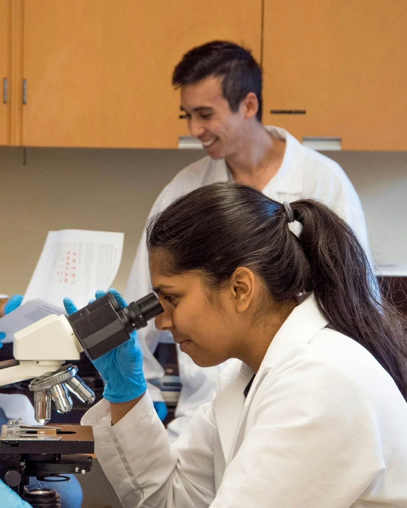 Student explores science in a lab setting through research placement coaching, learning how to find mentors, write outreach emails, and secure competitive research opportunities aligned with academic goals.
